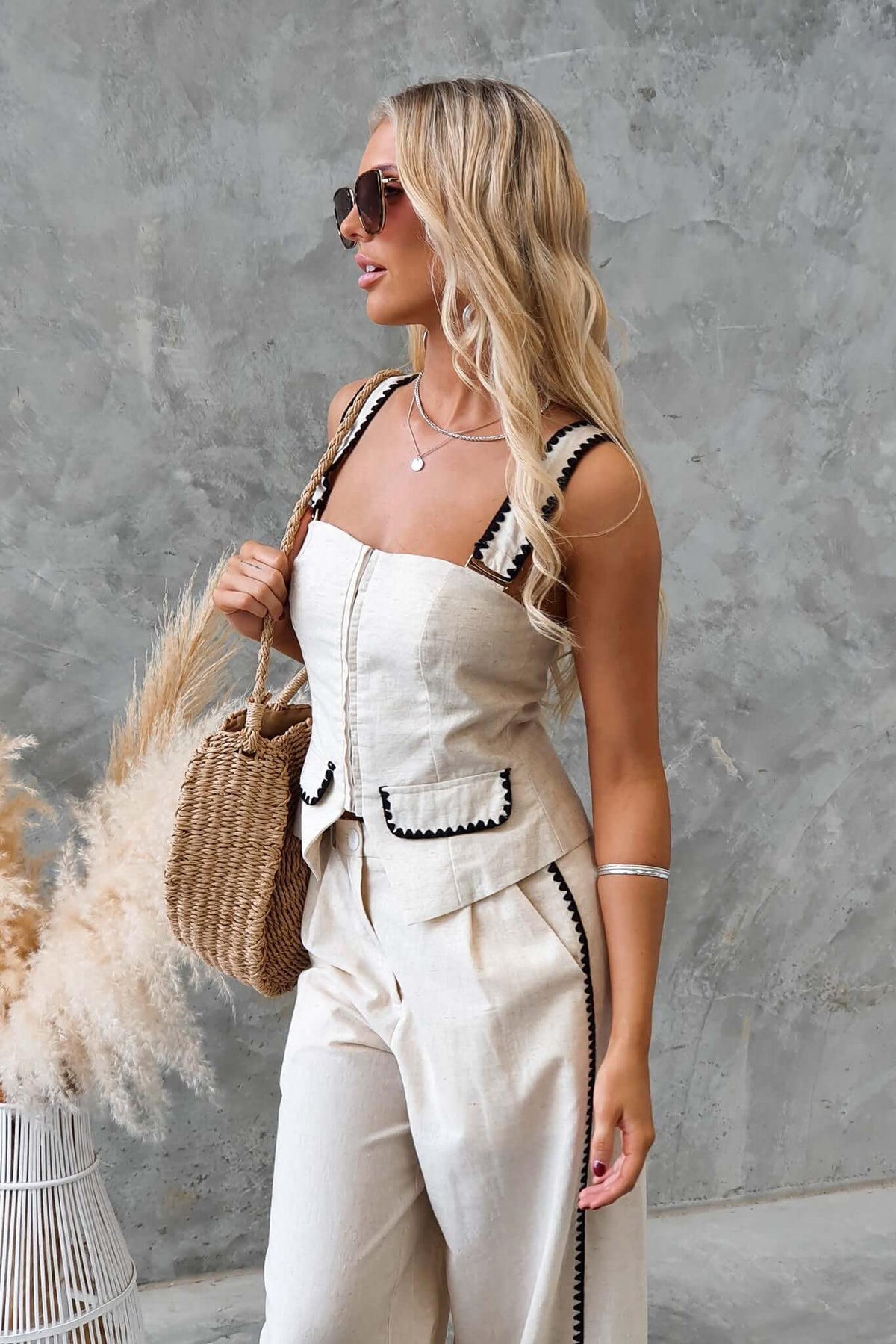 Woman wearing the Fallon Set with adjustable straps, faux pockets, and stylish sunglasses, showcasing a chic summer look.