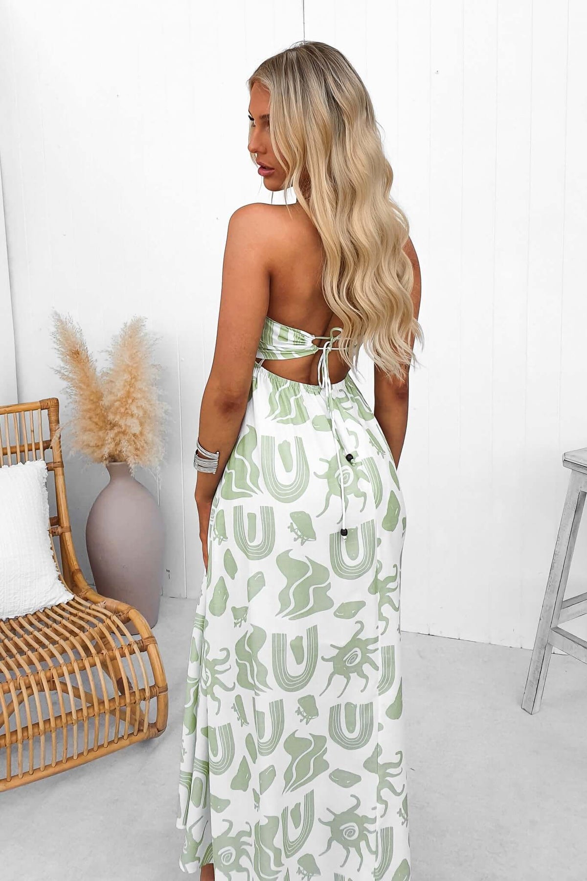 Model wearing Derry Maxi Dress with adjustable tie straps and square neckline, showcasing the back design and elegant pattern.
