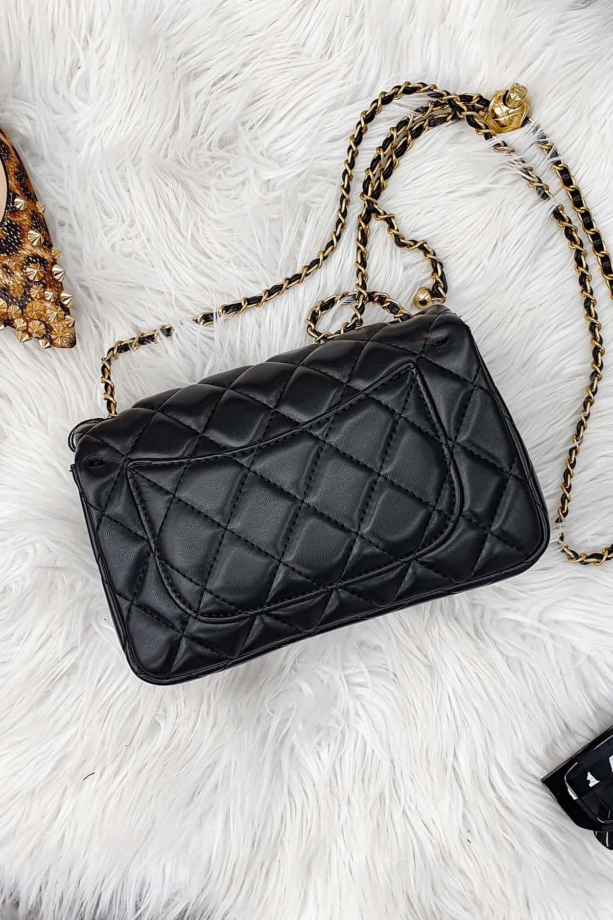 Chelsea Bag featuring a chic quilted finish, gold hardware, and stylish chain strap on a fluffy white background.