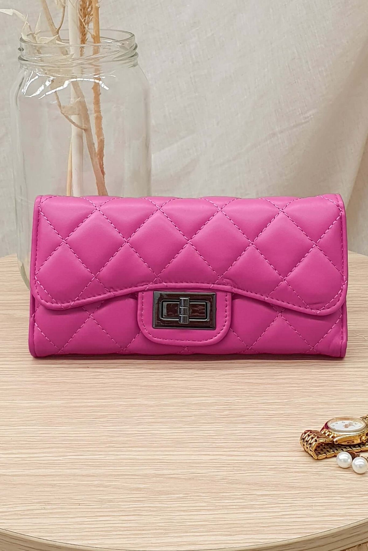 Asta Wallet in pink vegan leather, featuring quilted design and silver clasp, ideal for day-to-night use.