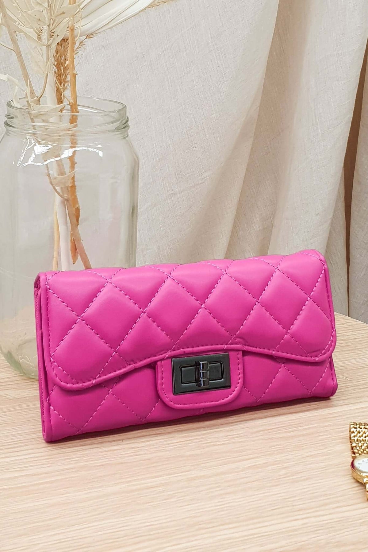 Asta Wallet in vibrant pink vegan leather, featuring quilted design, stylish buckle, and spacious interior for essentials.