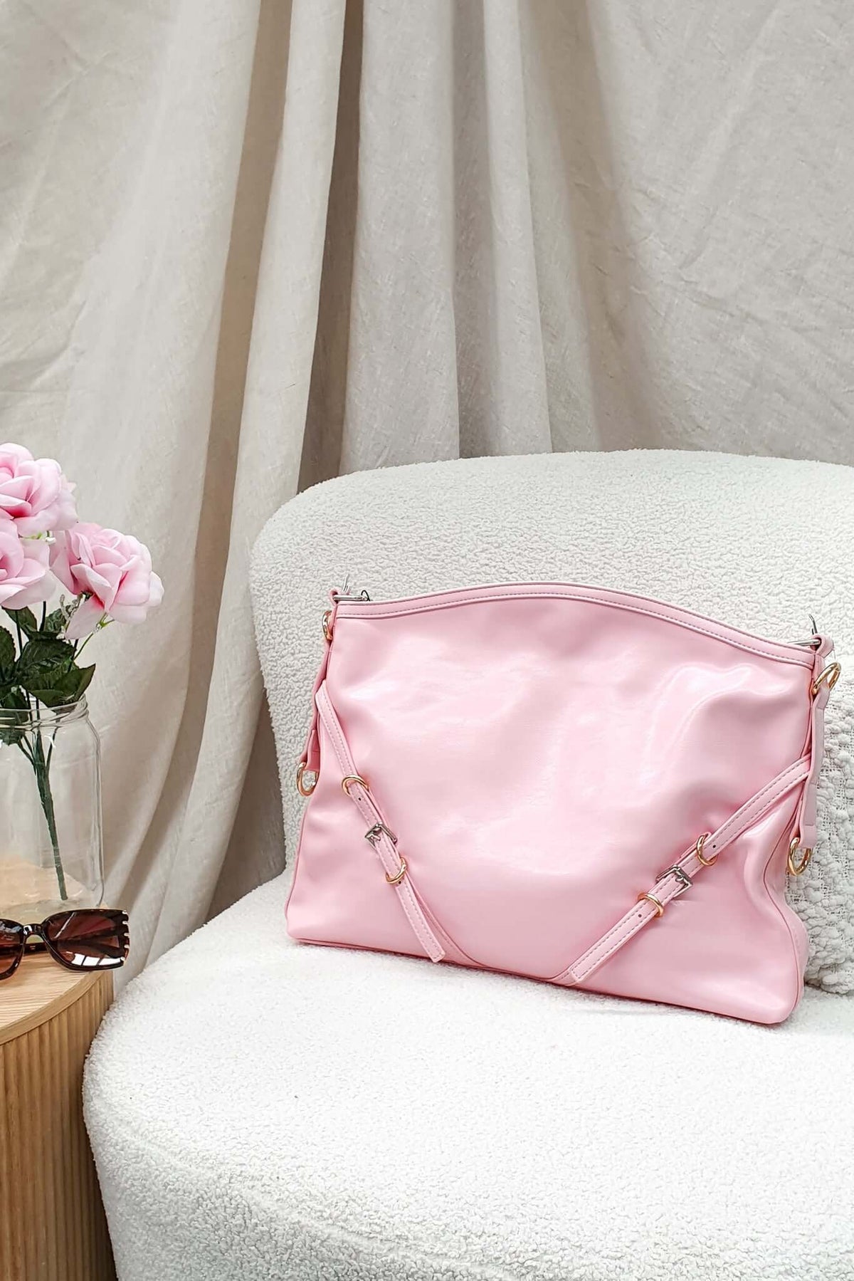 Stylish pink Bily Bag resting on a white chair next to sunglasses and pink flowers, perfect for elevating any tote collection.