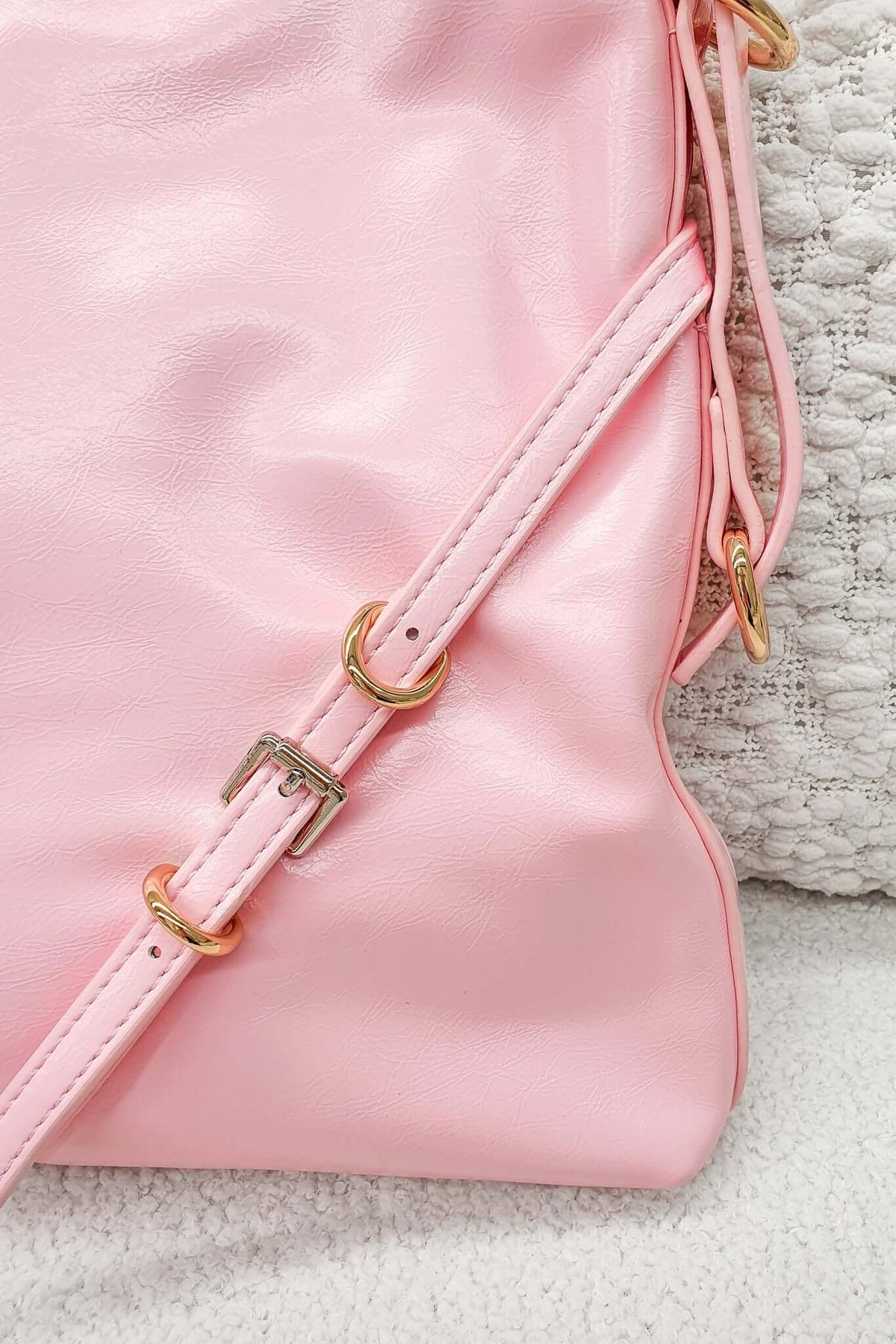 Close-up of a pink Bily Bag shoulder strap featuring gold hardware, showcasing a stylish tote design.