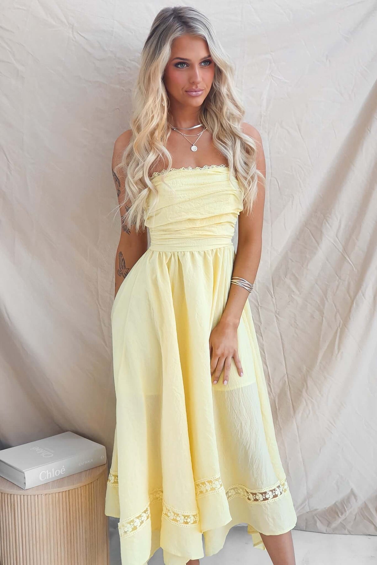 Civita Maxi Dress: Strapless yellow dress with handkerchief hem, elastic back, and anti-slip bust detail.