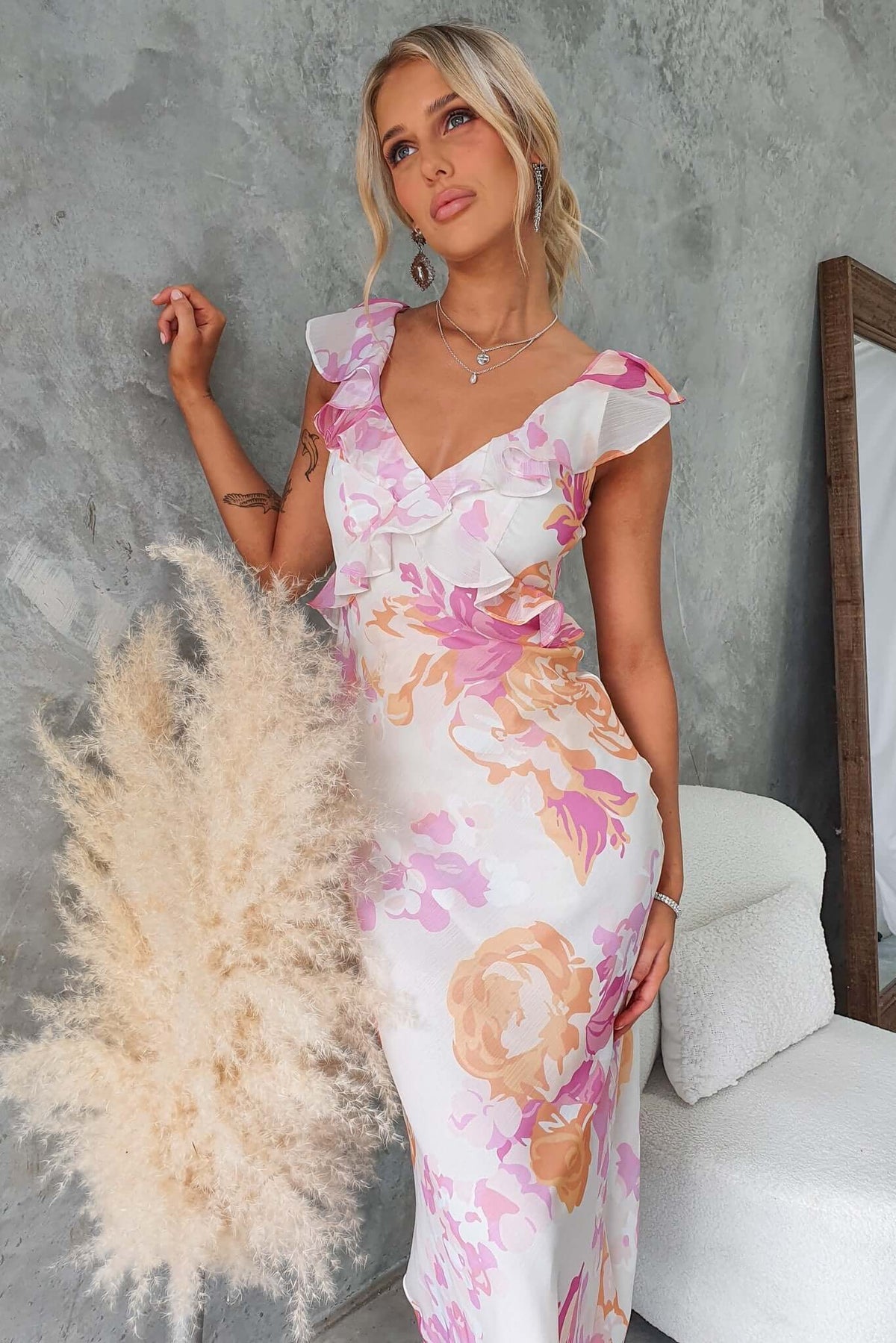 Elegant Bonnet Maxi Dress with V-neckline and ruffle detail, featuring a floral design in soft pastel colors.