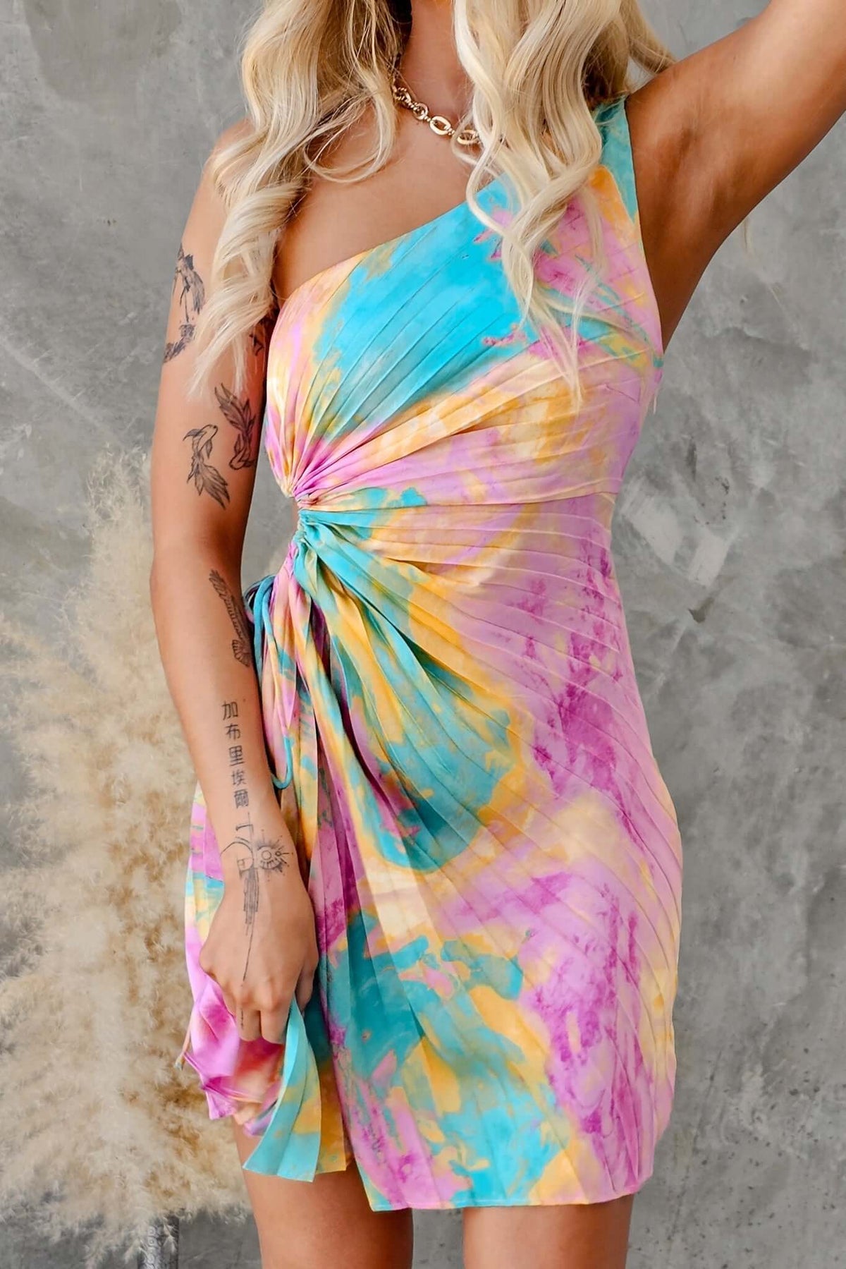 Montrose Dress featuring a one-shoulder neckline, cut-out waist, and colorful accordion pleat fabric.