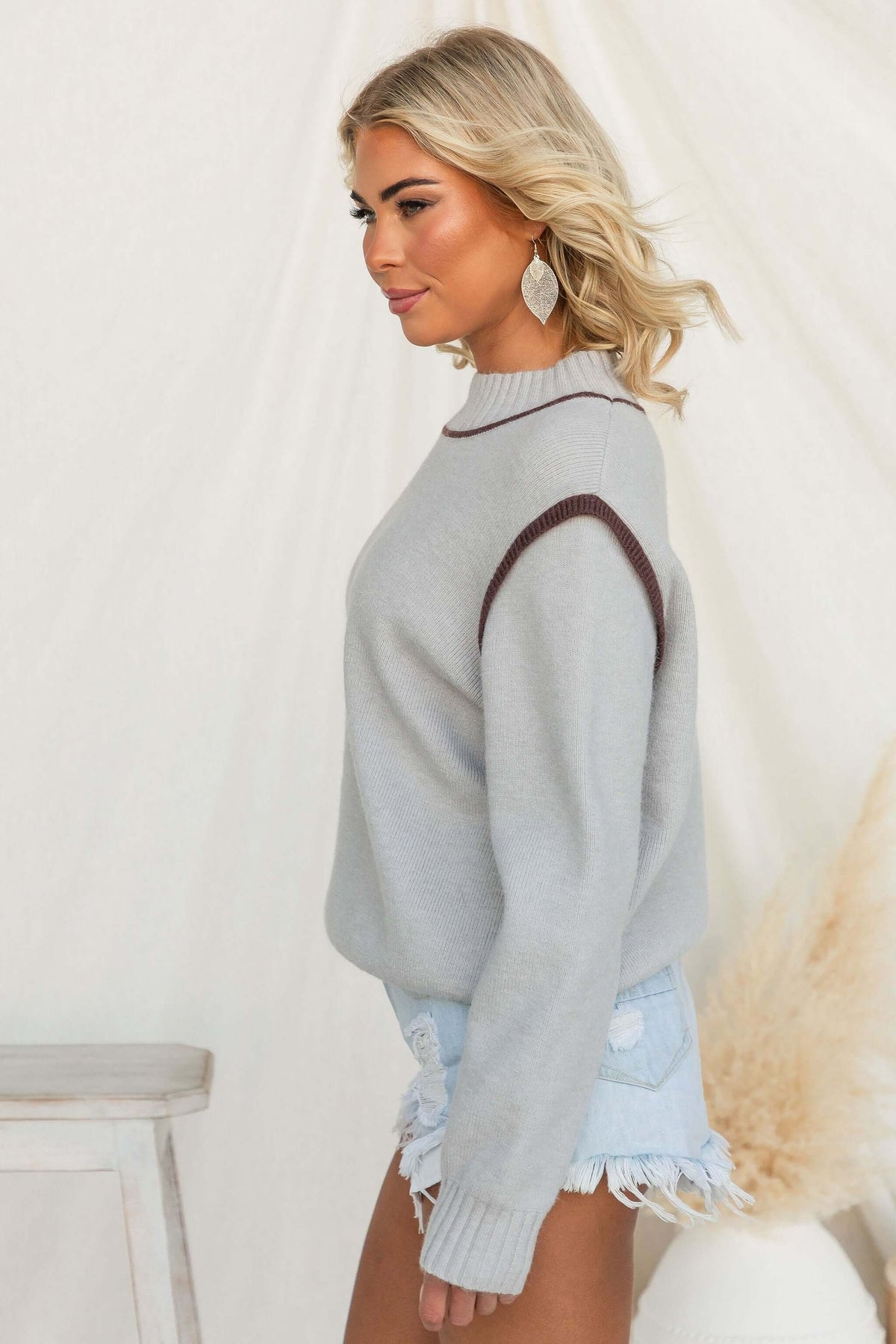 Nights Out Jumper in grey, featuring a mock neckline and relaxed fit, worn with denim shorts.