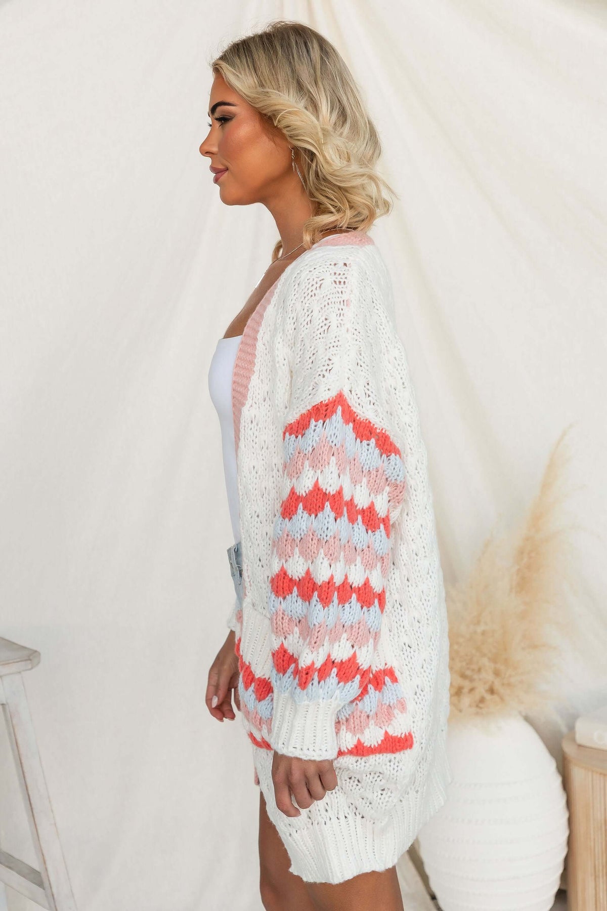 Side view of a model wearing the Wild Romance Cardigan with colorful textured sleeves and a relaxed fit.