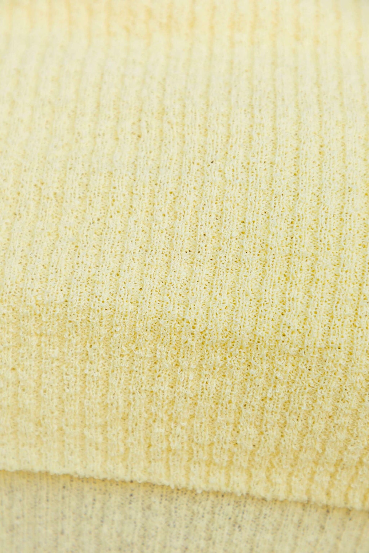 Close-up of ribbed knit material in soft yellow for the Breeze Midi Dress