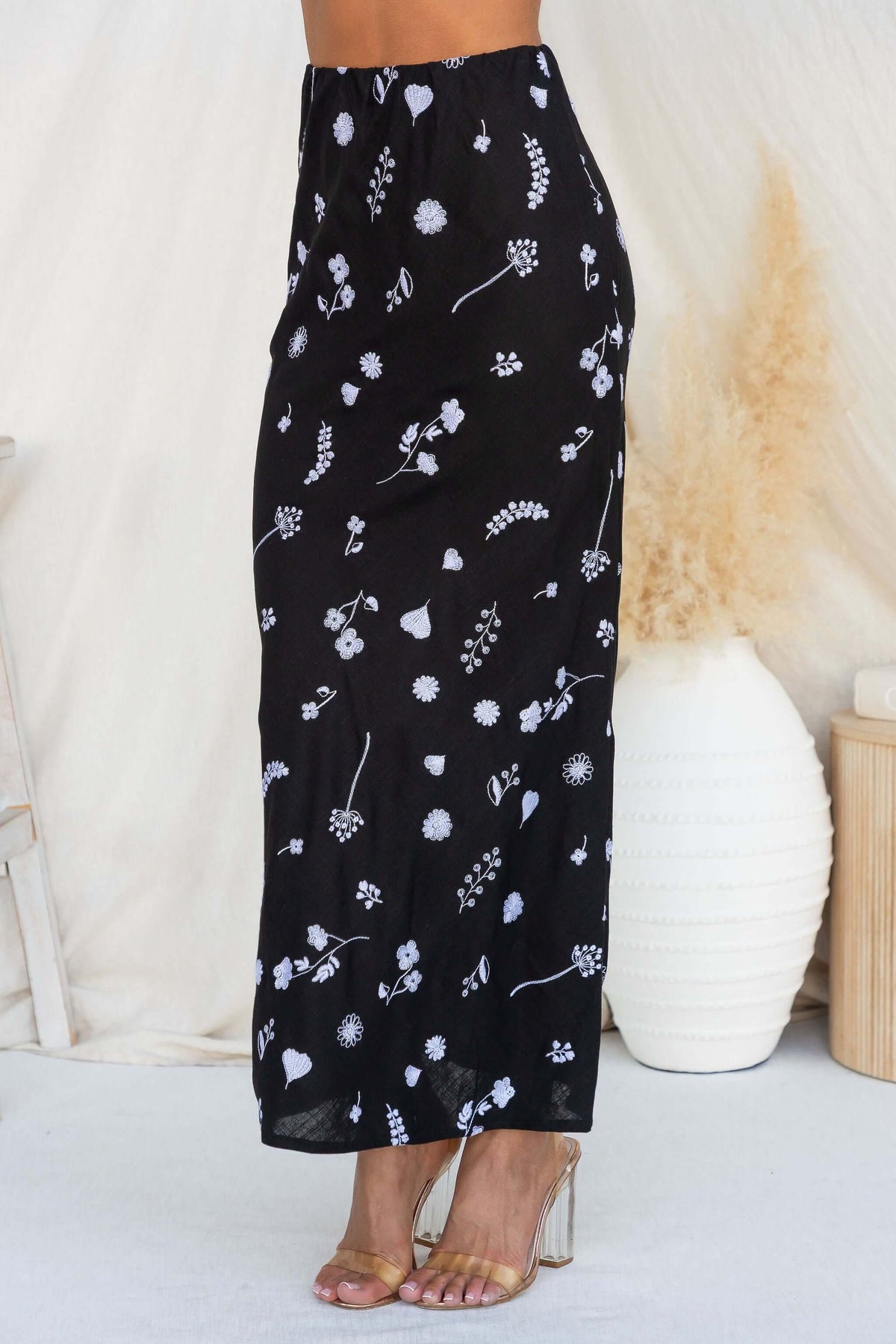 Lune Maxi Skirt featuring a black floral design, non-lined fabric, and mid-high waist fit with elastic waistband.