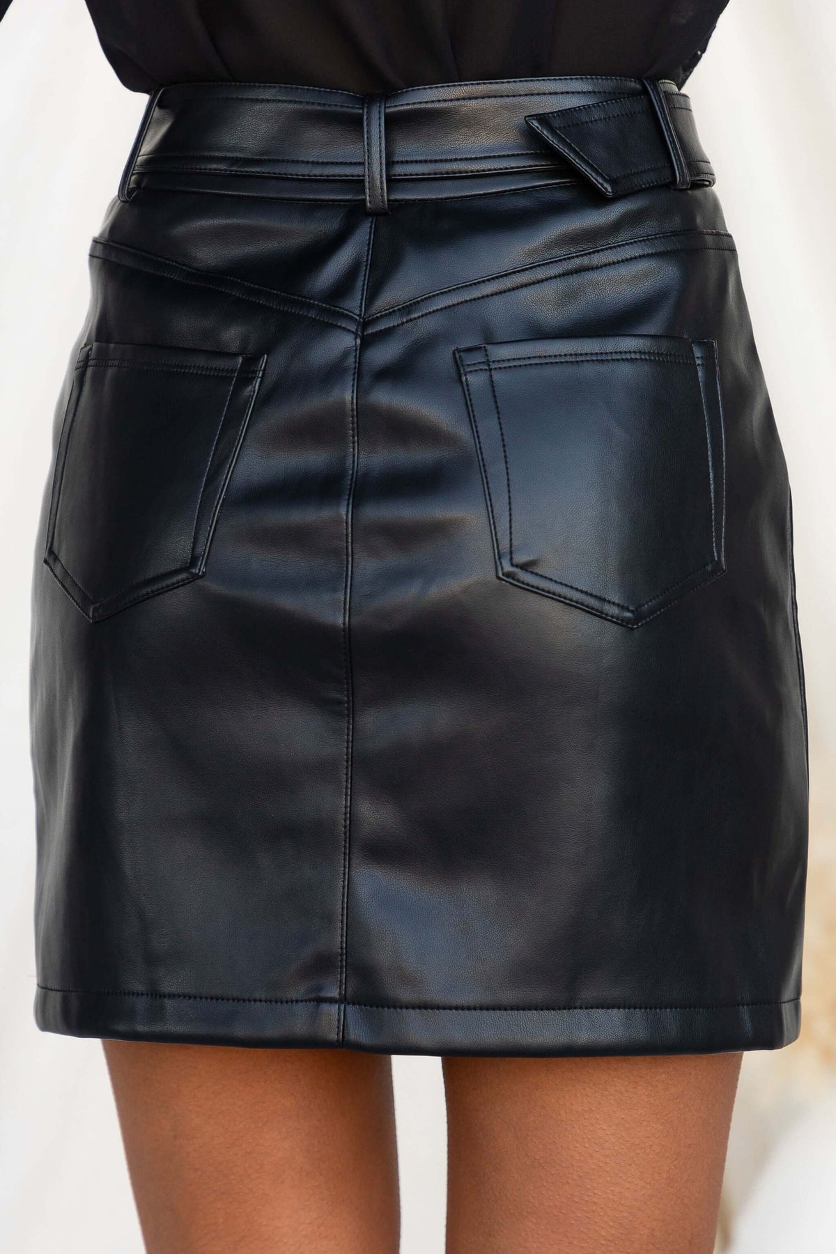 Close-up of the back view of the Promise Skirt made of faux leather with pockets and removable belt.