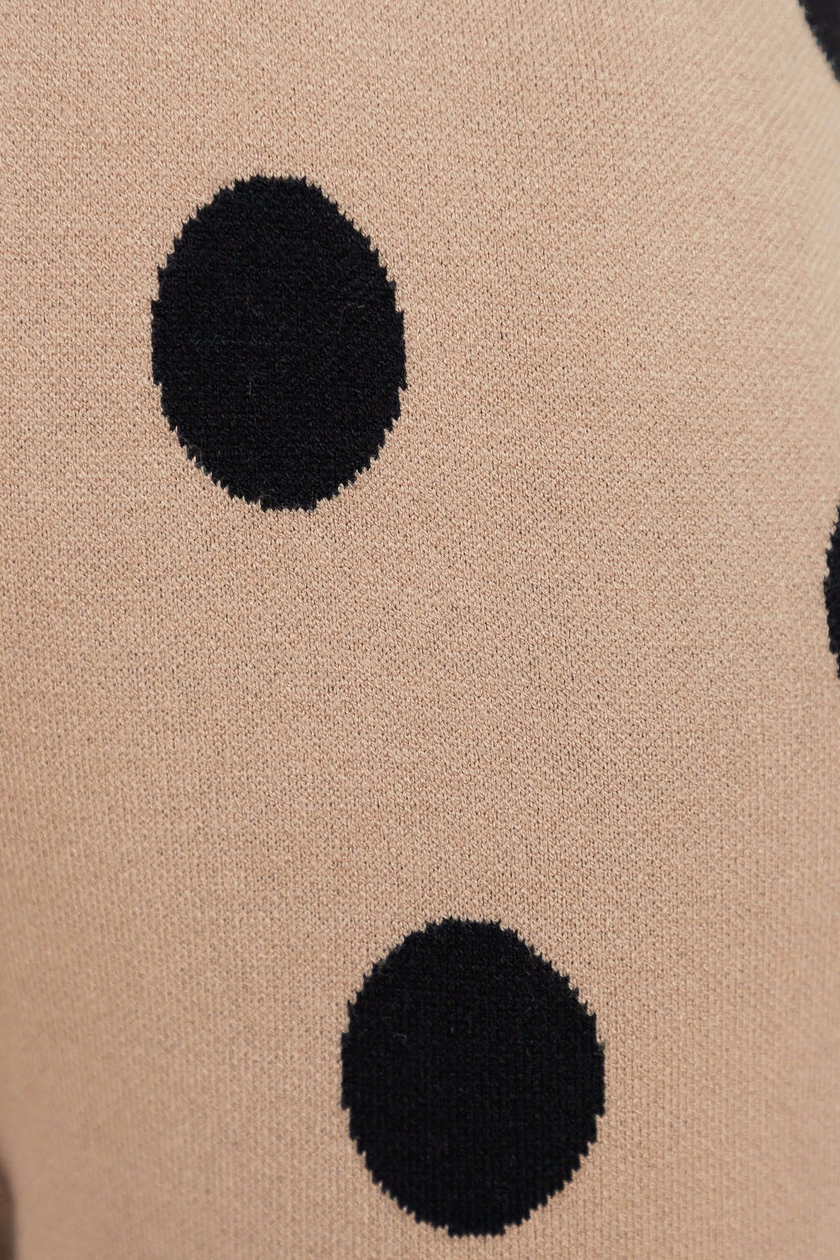 Close-up of the knit fabric of the Elise Set featuring large black polka dots on a beige background.