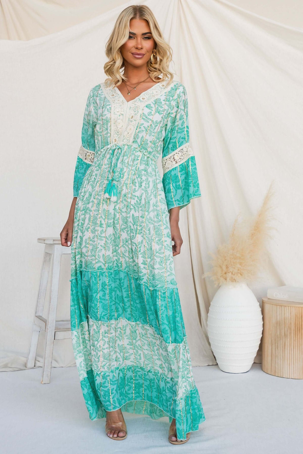 Fashion model wearing a Mystic Maxi Dress with a V-neckline, elastic waistband, and floral print.