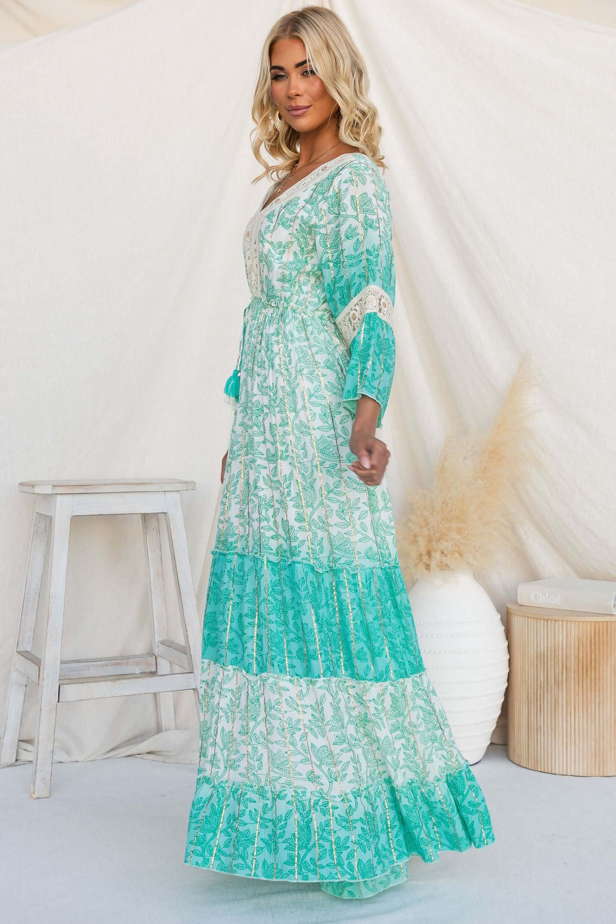 Model wearing a Mystic Maxi Dress with a V-neckline and floral print, showcasing boho style and pockets.
