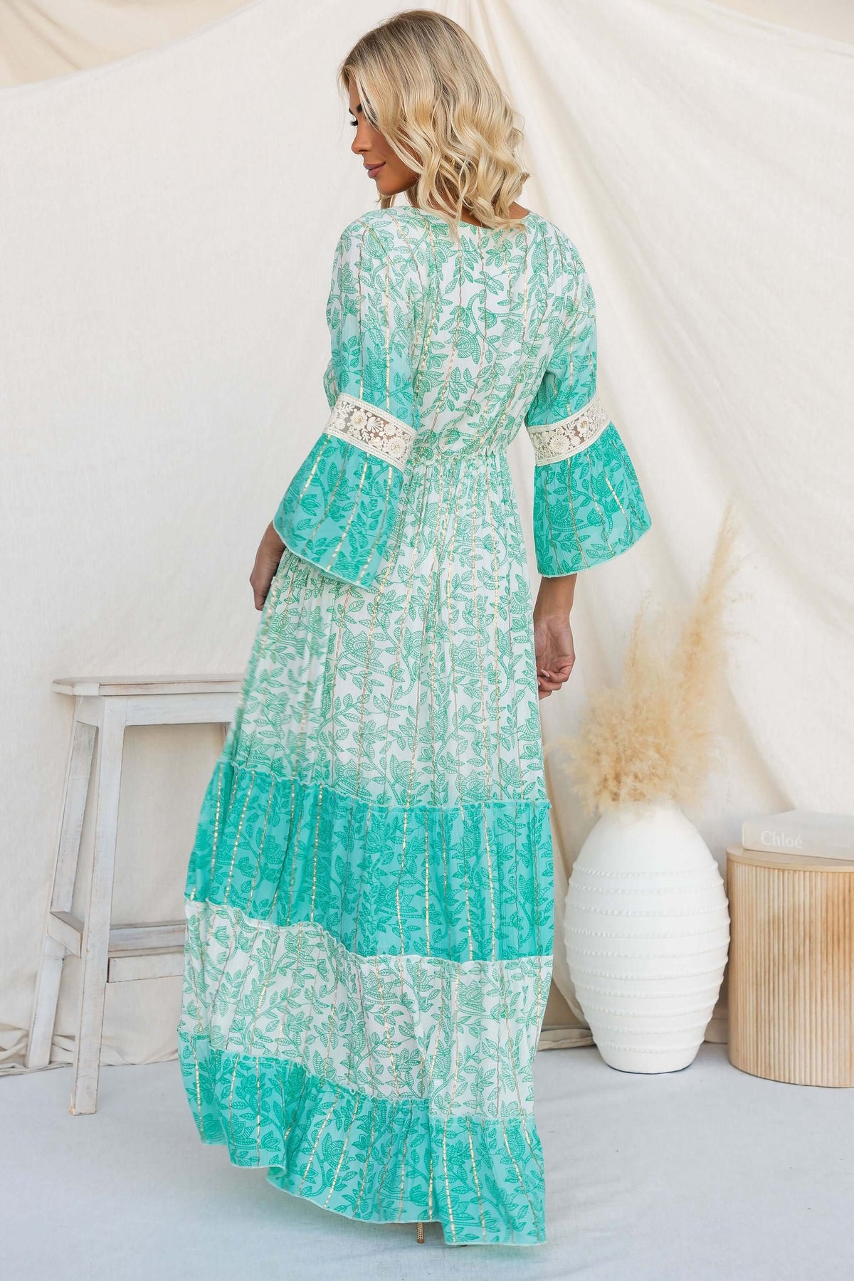 Back view of the Mystic Maxi Dress with bell sleeves and floral pattern, styled against a neutral backdrop.