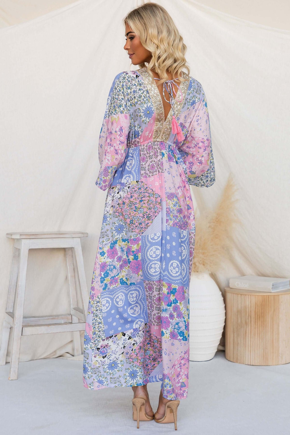 Model wearing Endless Evening Maxi Dress with floral patterns and open back design.