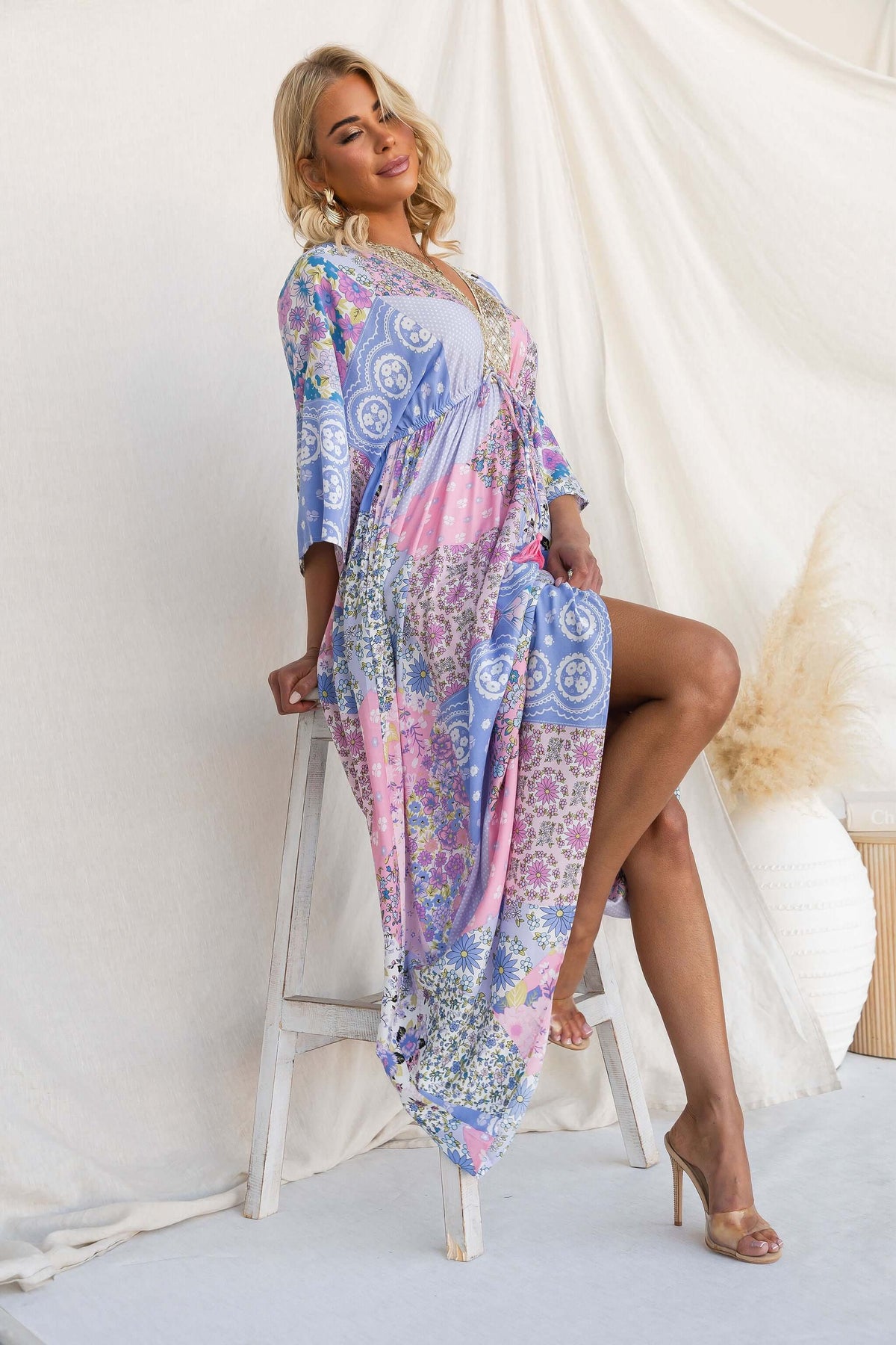 Model wearing Endless Evening Maxi Dress with a V-neckline and floral patterns, styled with metallic detailing.