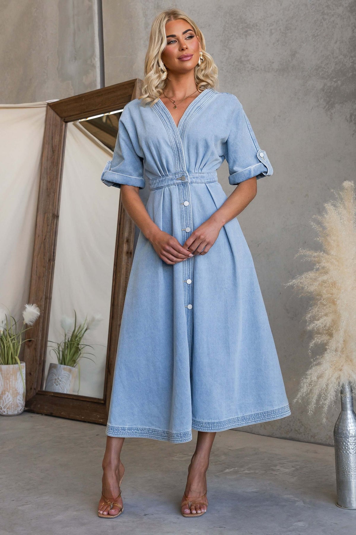 Saddle Bloom Denim Midi Dress displayed on model, featuring a V-neckline and button-up front in light denim fabric.