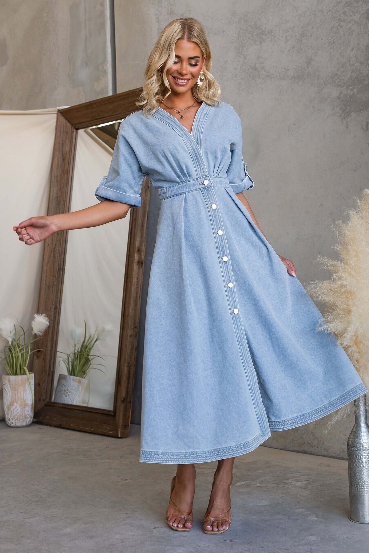 Model showcasing the Saddle Bloom Denim Midi Dress with a V-neckline and button-up front.