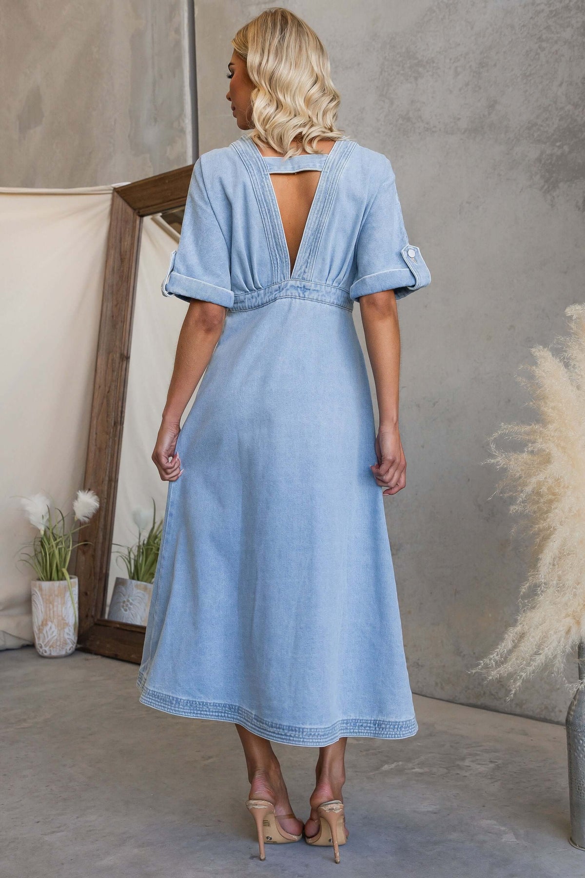 Back view of Saddle Bloom Denim Midi Dress showcasing the V-neckline and button detail.