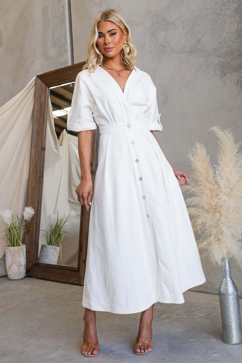 Model wearing Saddle Bloom Denim Midi Dress with a V-neckline and button-up front in a stylish setting.