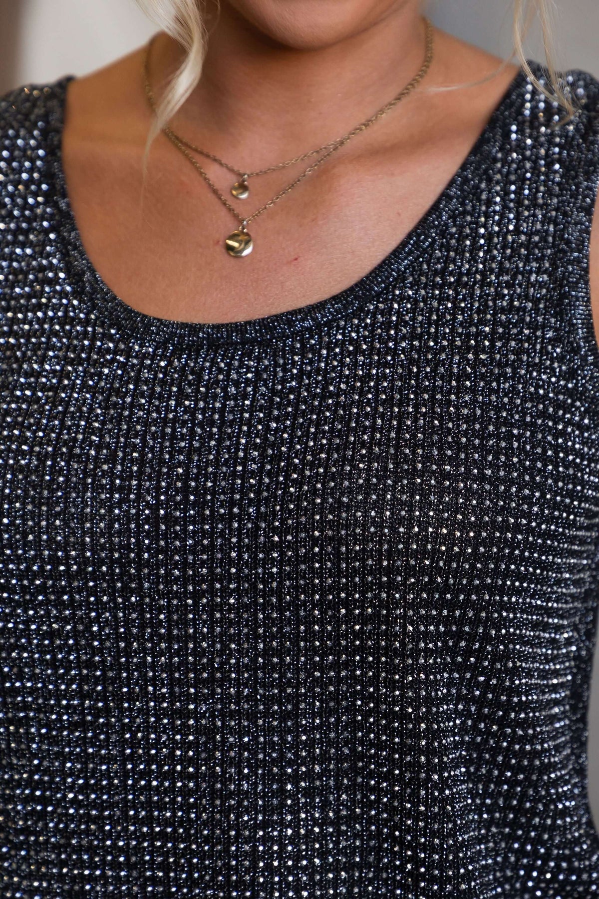 Close-up of the Club City Top featuring a knit black fabric with diamantes and a round neckline.