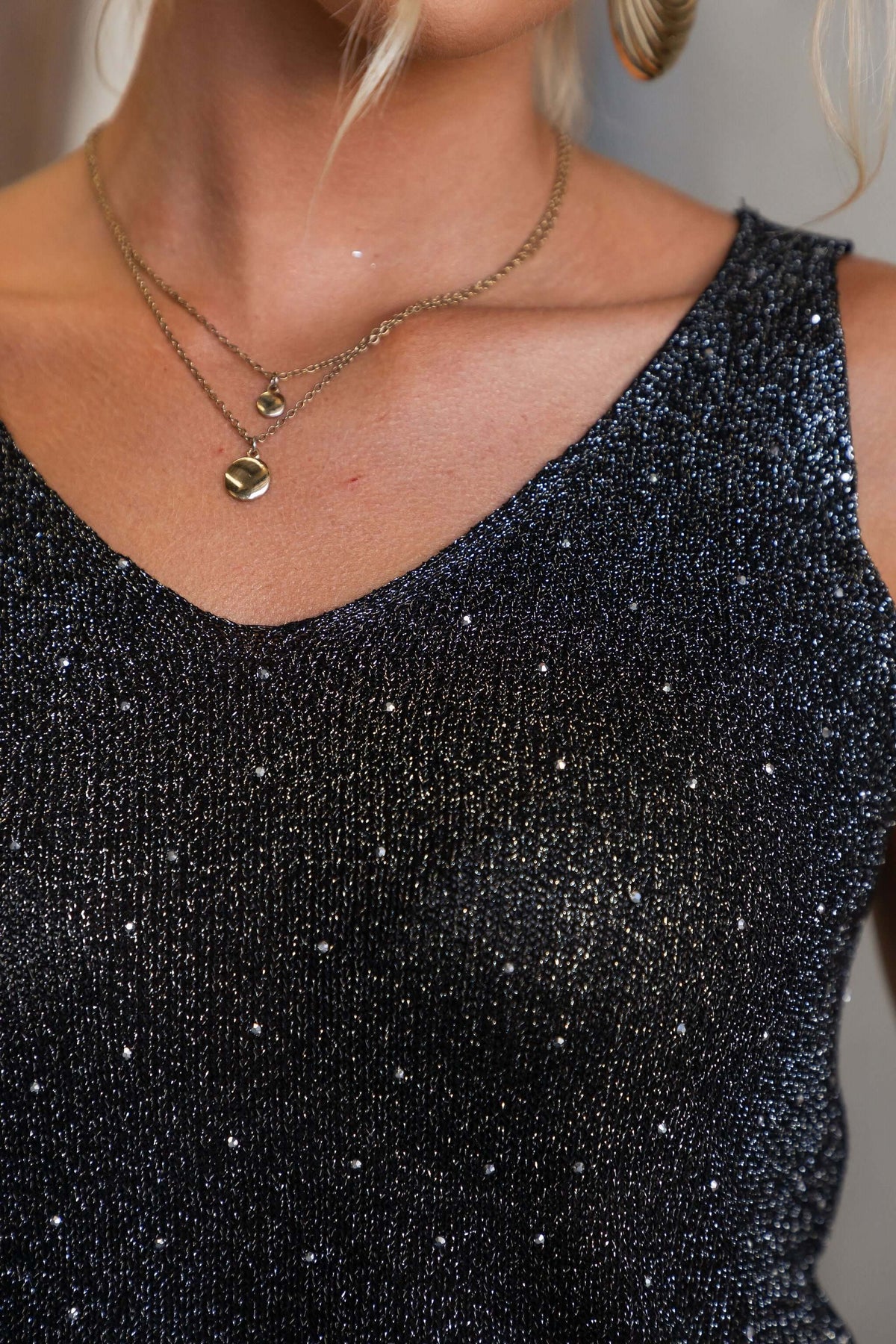 Close-up of the V-neckline of the Starlit Top, showcasing knit material with diamantes and a relaxed fit.