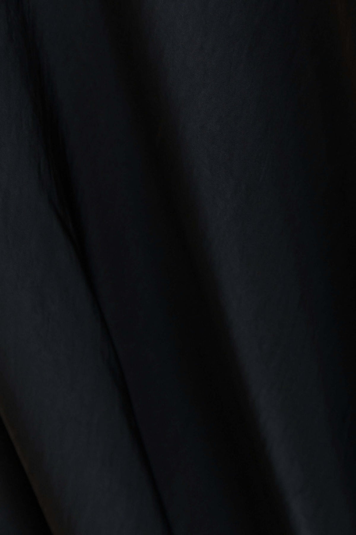 Close-up of the fabric texture of the Moonlit Muse Maxi Skirt in black satin material.