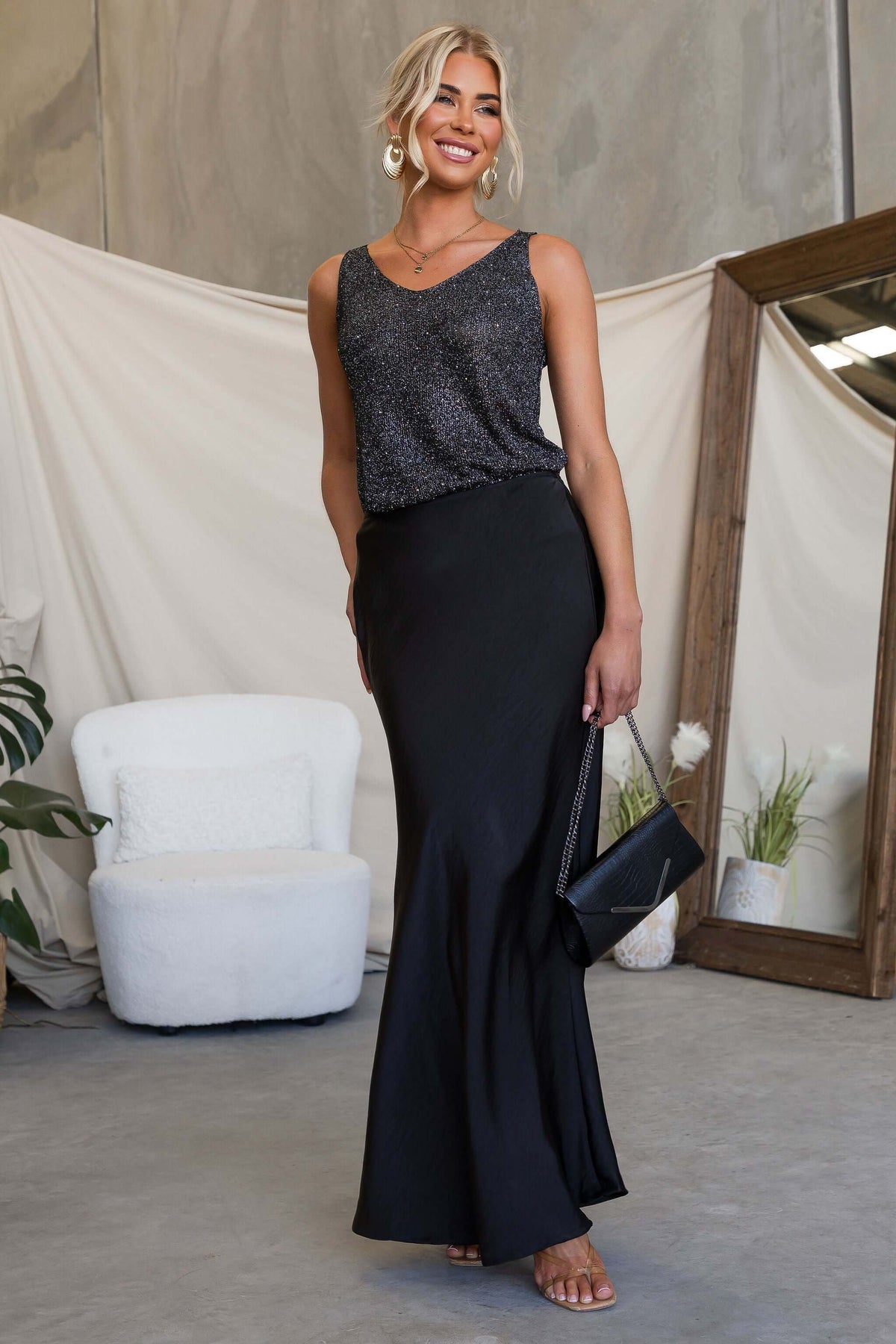 Model wearing Moonlit Muse Maxi Skirt paired with a sparkly top and handbag in a stylish setting.