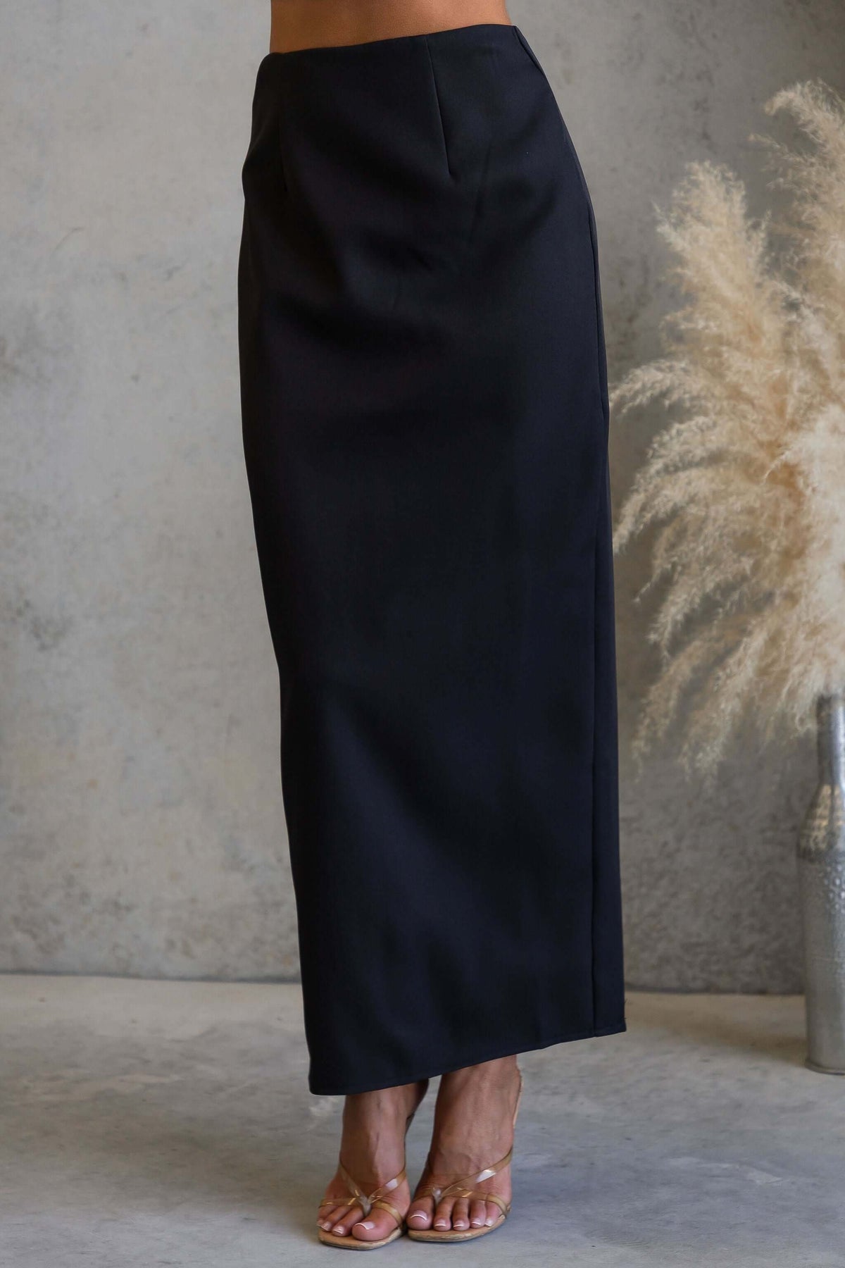 Duchess Maxi Skirt in black showcased on a model, featuring a mid-high waist and invisible zip at the back.