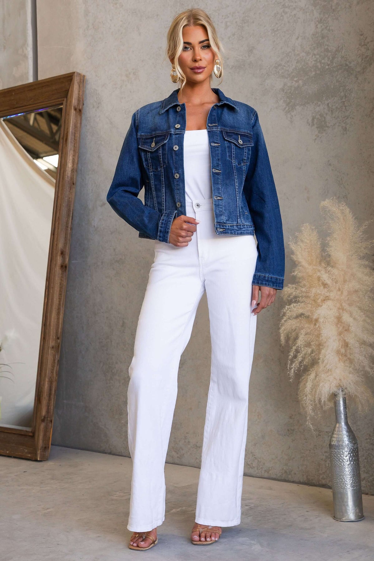Model wearing Coyote Denim Jacket with white pants in stylish setting.