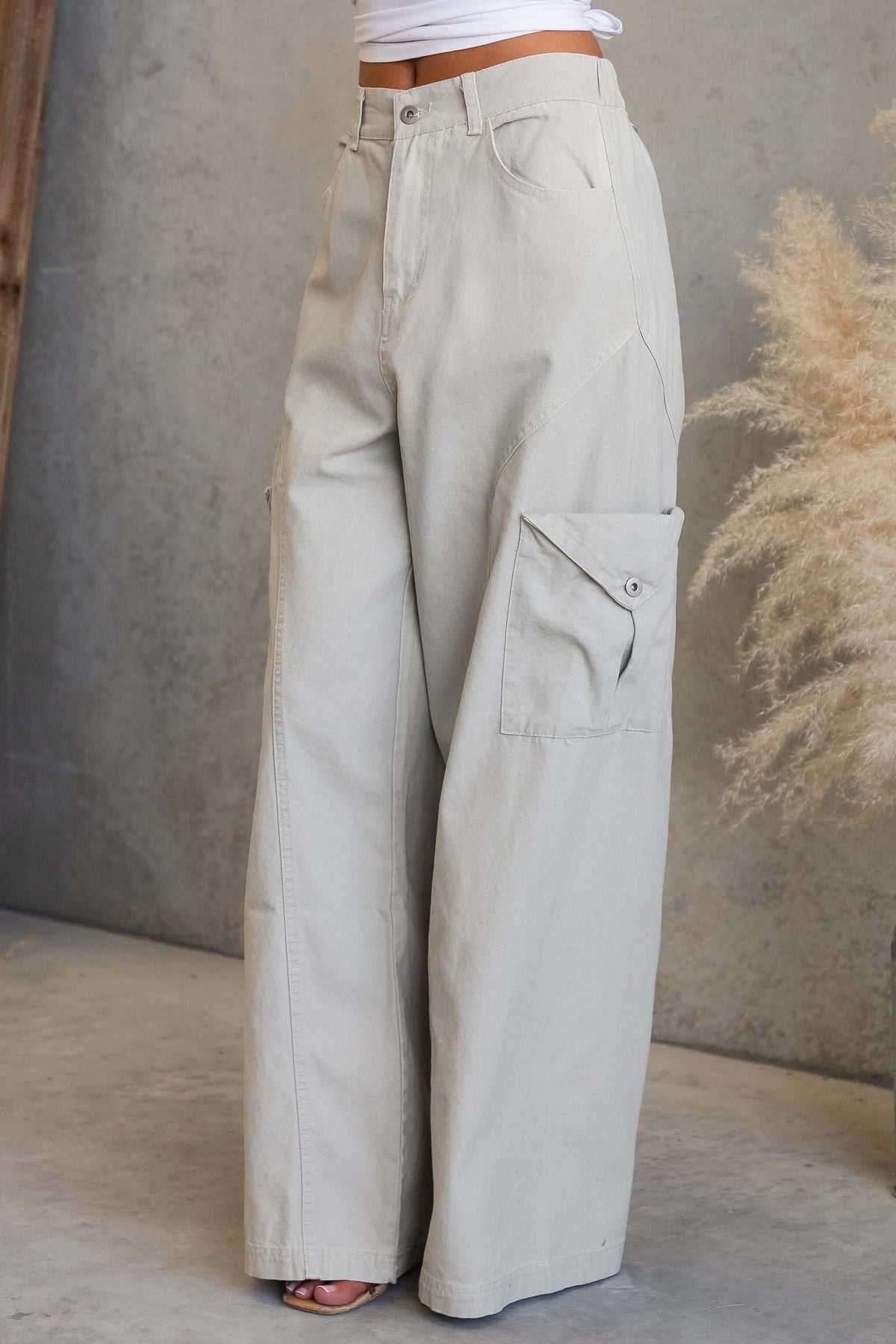 Rebel Cargo Jeans with mid-high waist fit, pockets, and zip/button closure in a light color.
