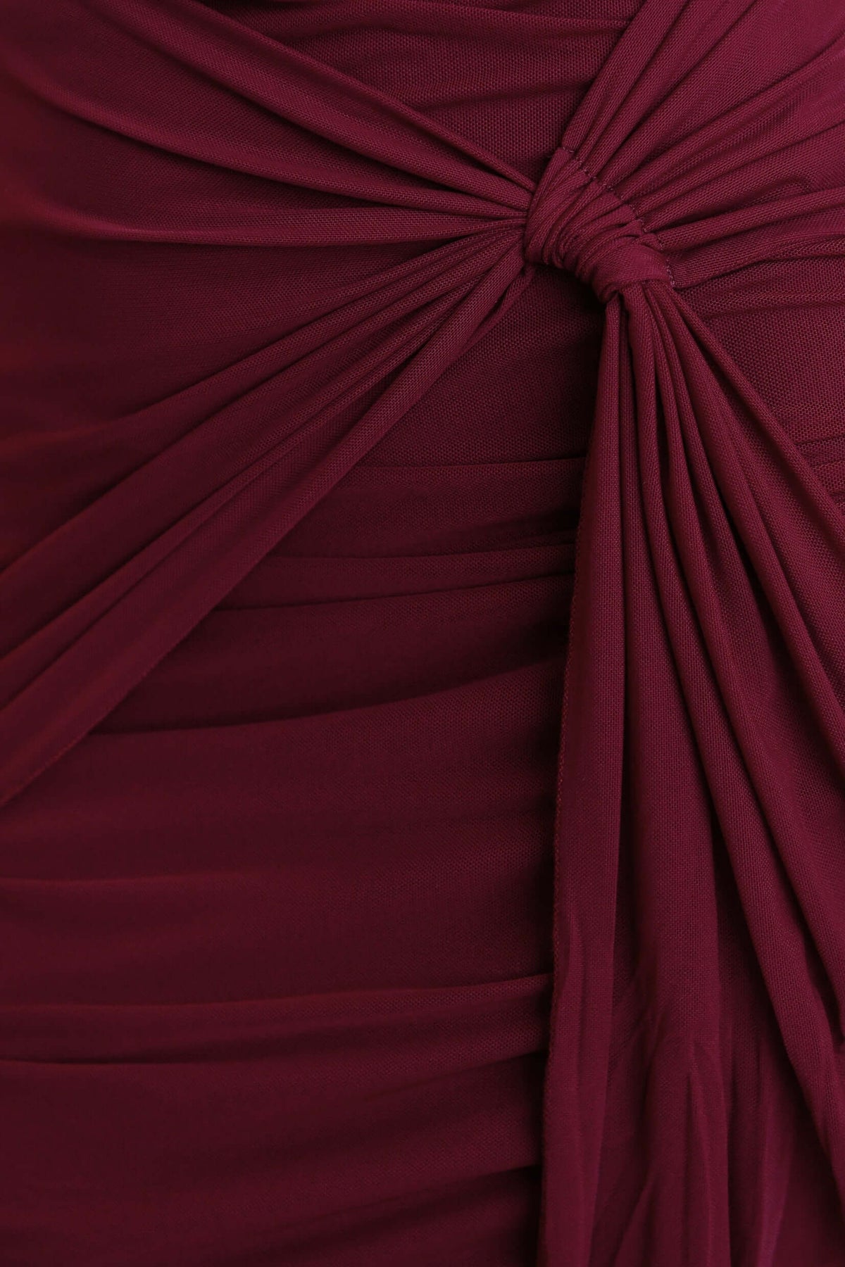 Close-up detail of the Invite Only Dress showcasing draping detail and rich burgundy mesh fabric.