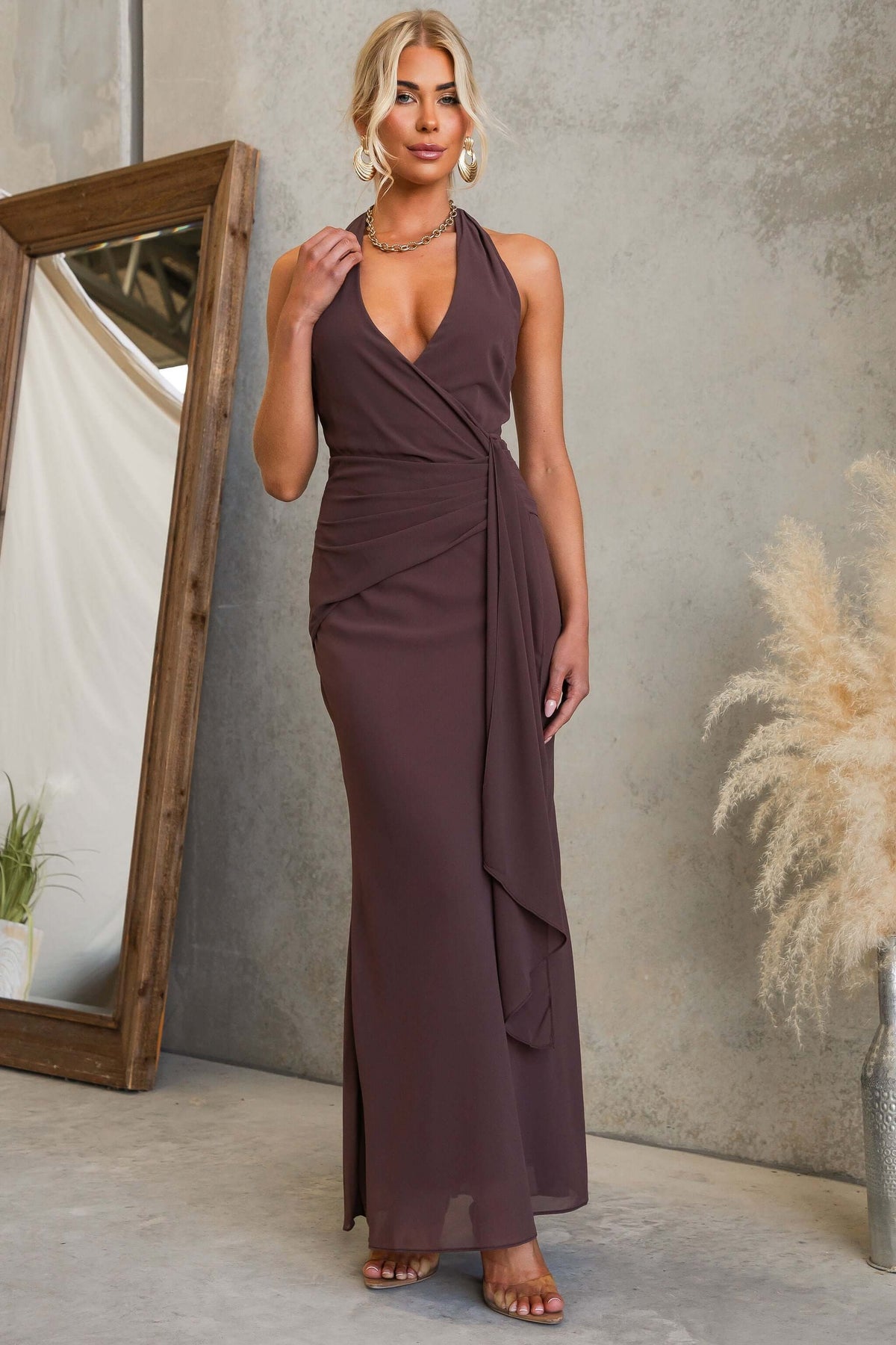 Model wearing a Valmont Maxi Dress with a halter neckline and draping material, showcasing its elegant design.