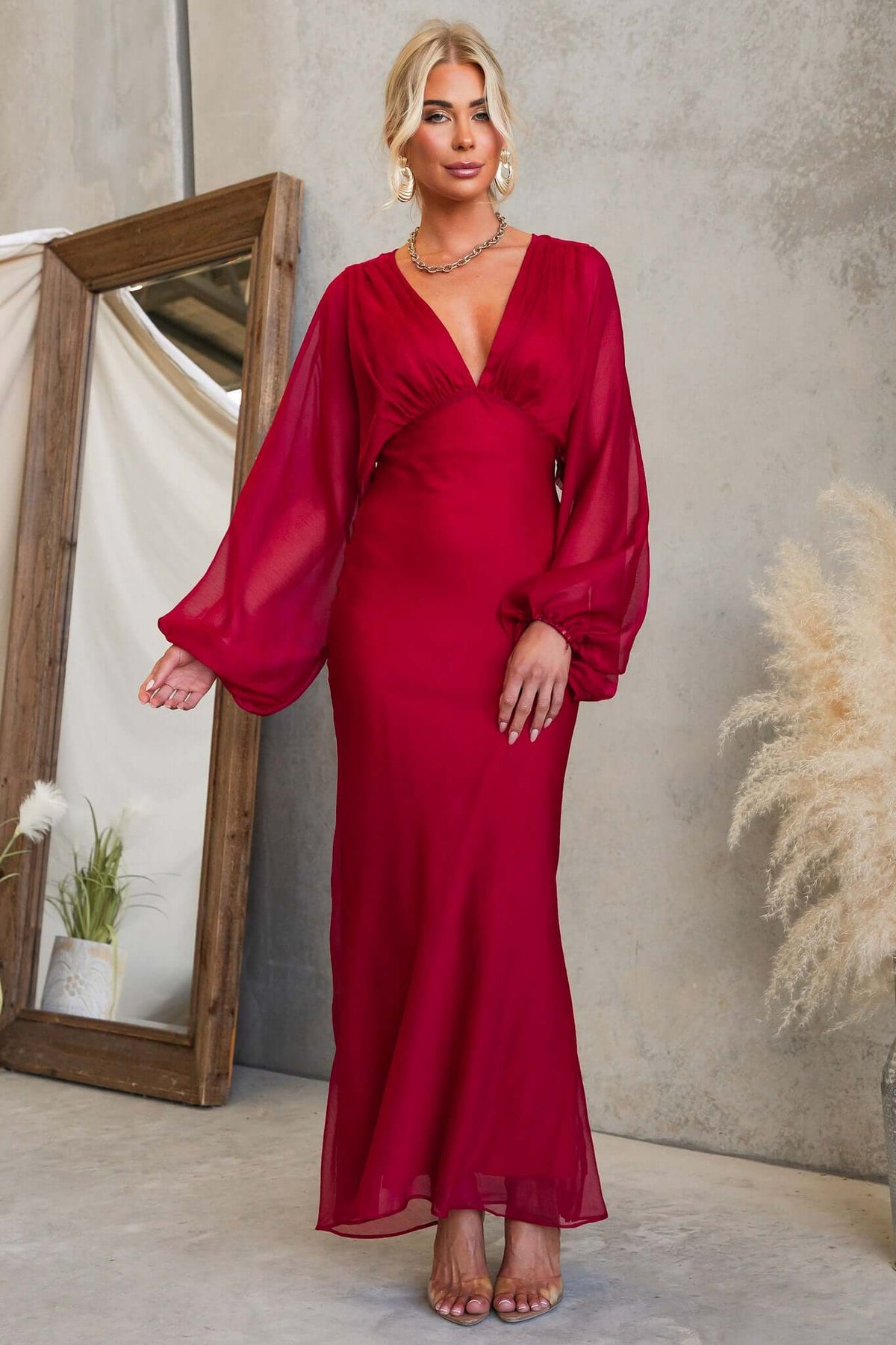 Beautiful model wearing the Nightfall Maxi Dress with a V-neckline and billowy sleeves.