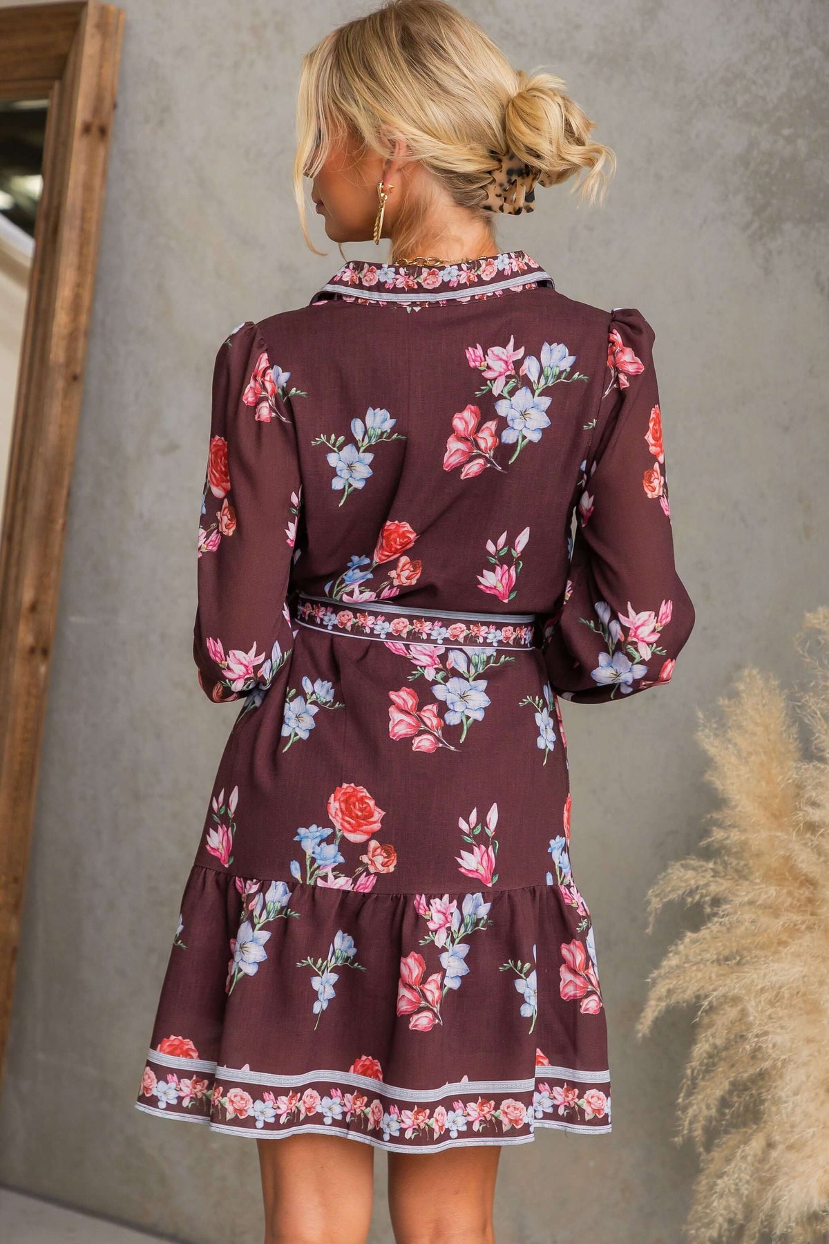 Back view of Fergy Dress with floral print featuring collar and tie, styled with elastic cuffs and pockets.