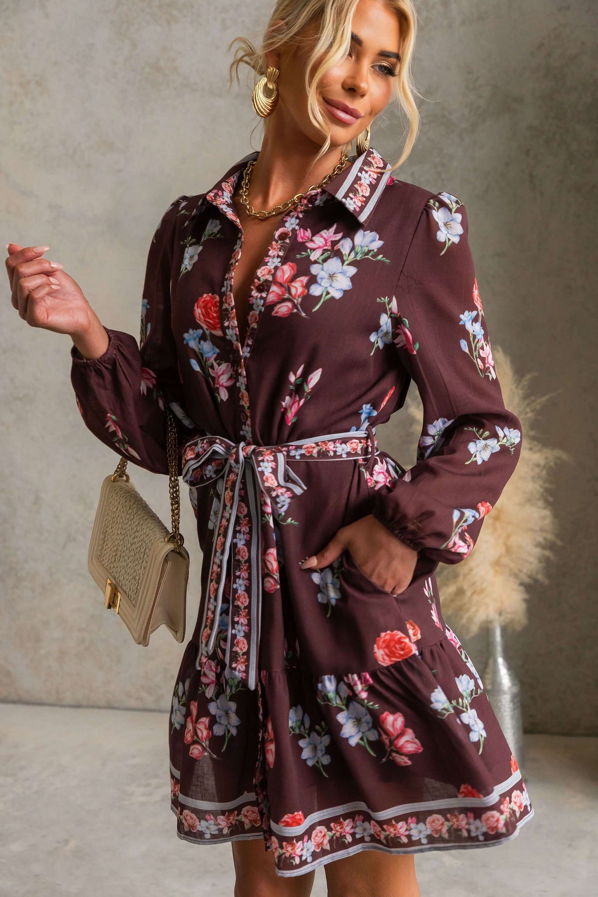 Model wearing Fergy Dress with floral design, collar, button-up front, and removable tie.