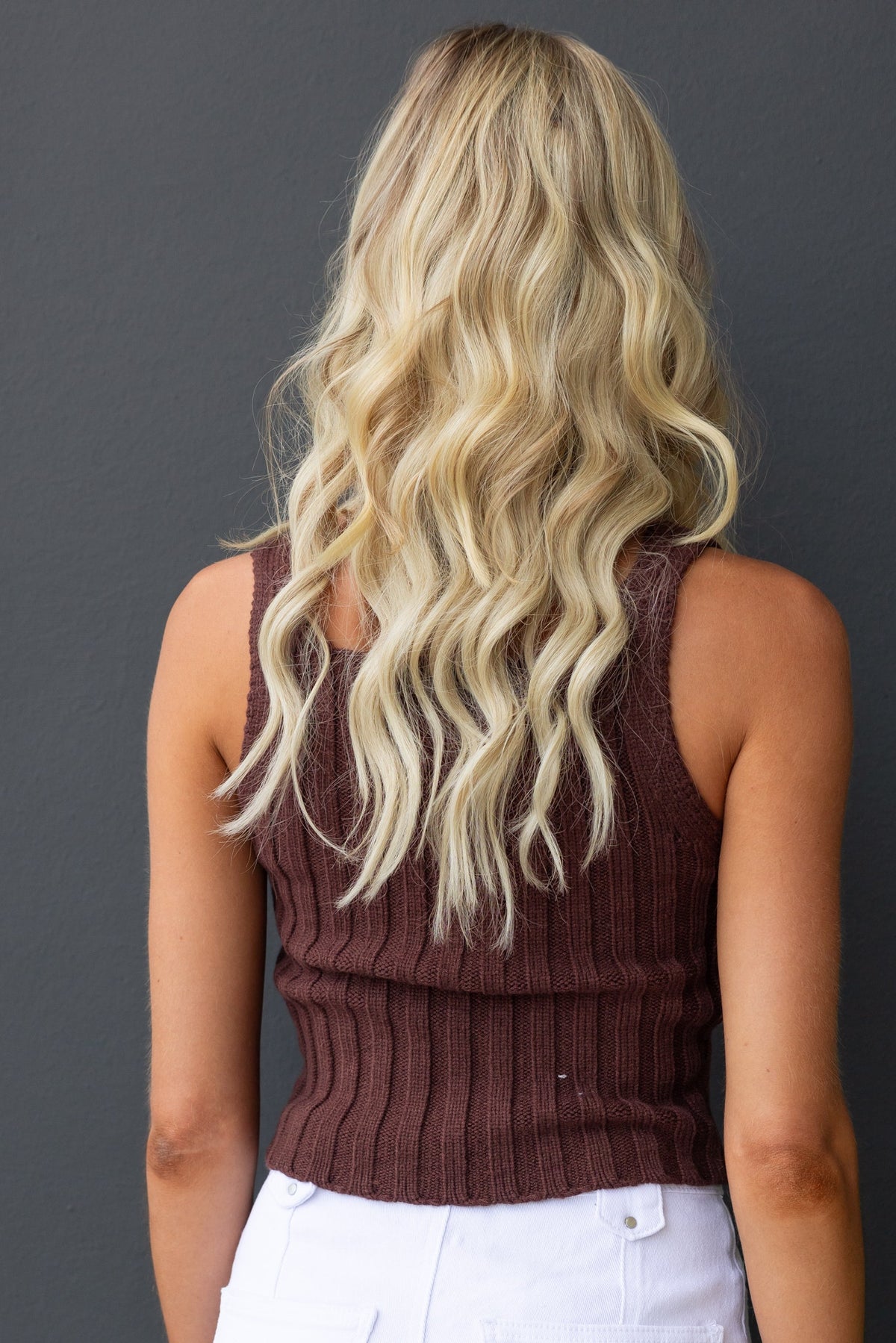 Model wearing a brown ribbed knit Aspen Top, showcasing a square neckline and styled hair.