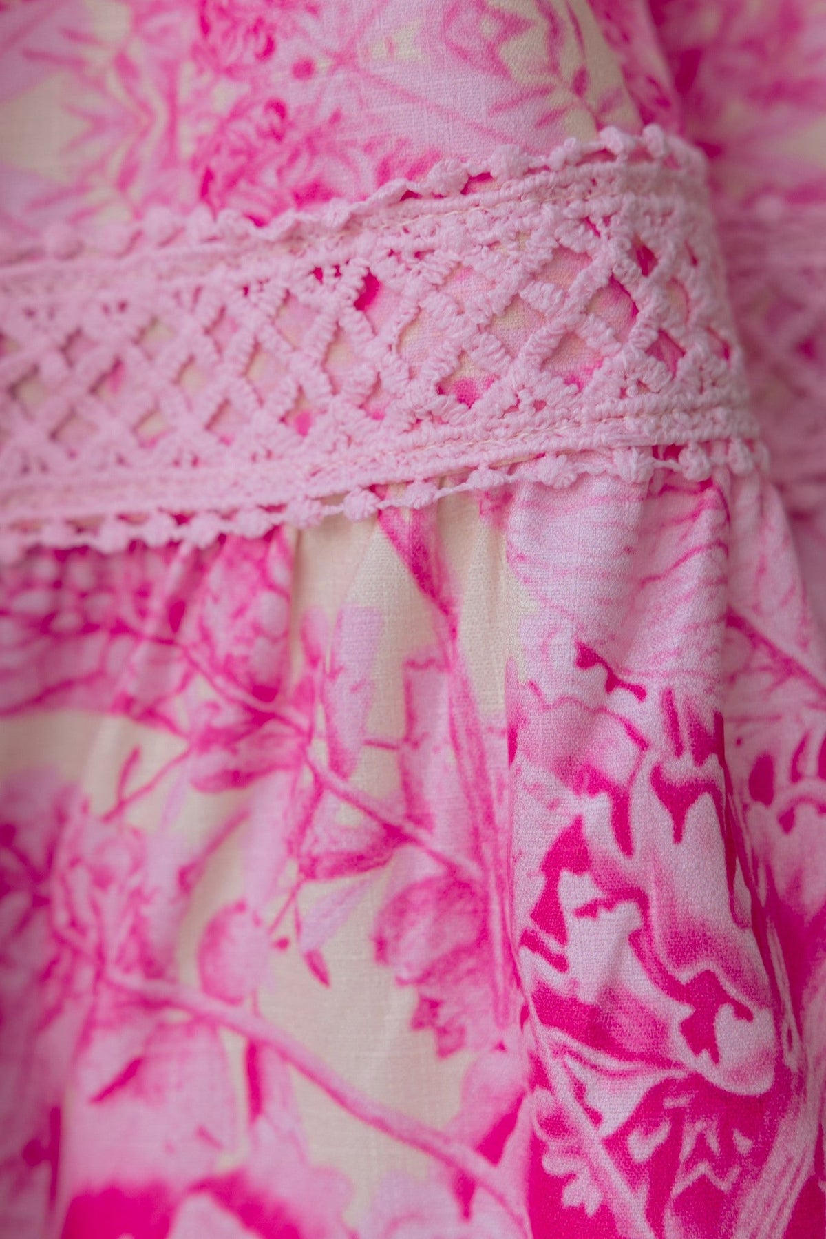 Close-up of the floral print fabric with pink hues and decorative lace trim on the Cillie Dress.