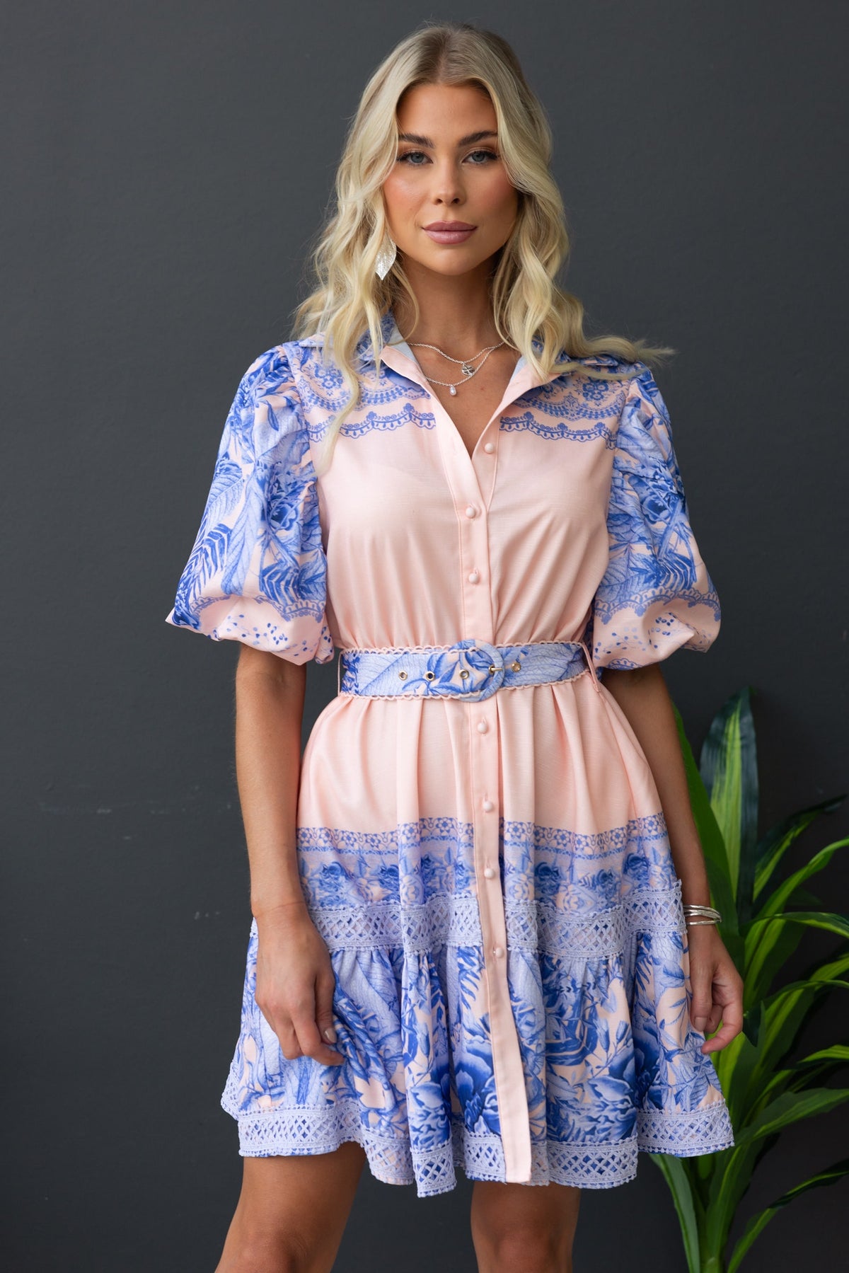 Cillie dress featuring a floral print, collar, button-up front, elastic sleeves, and a removable belt.