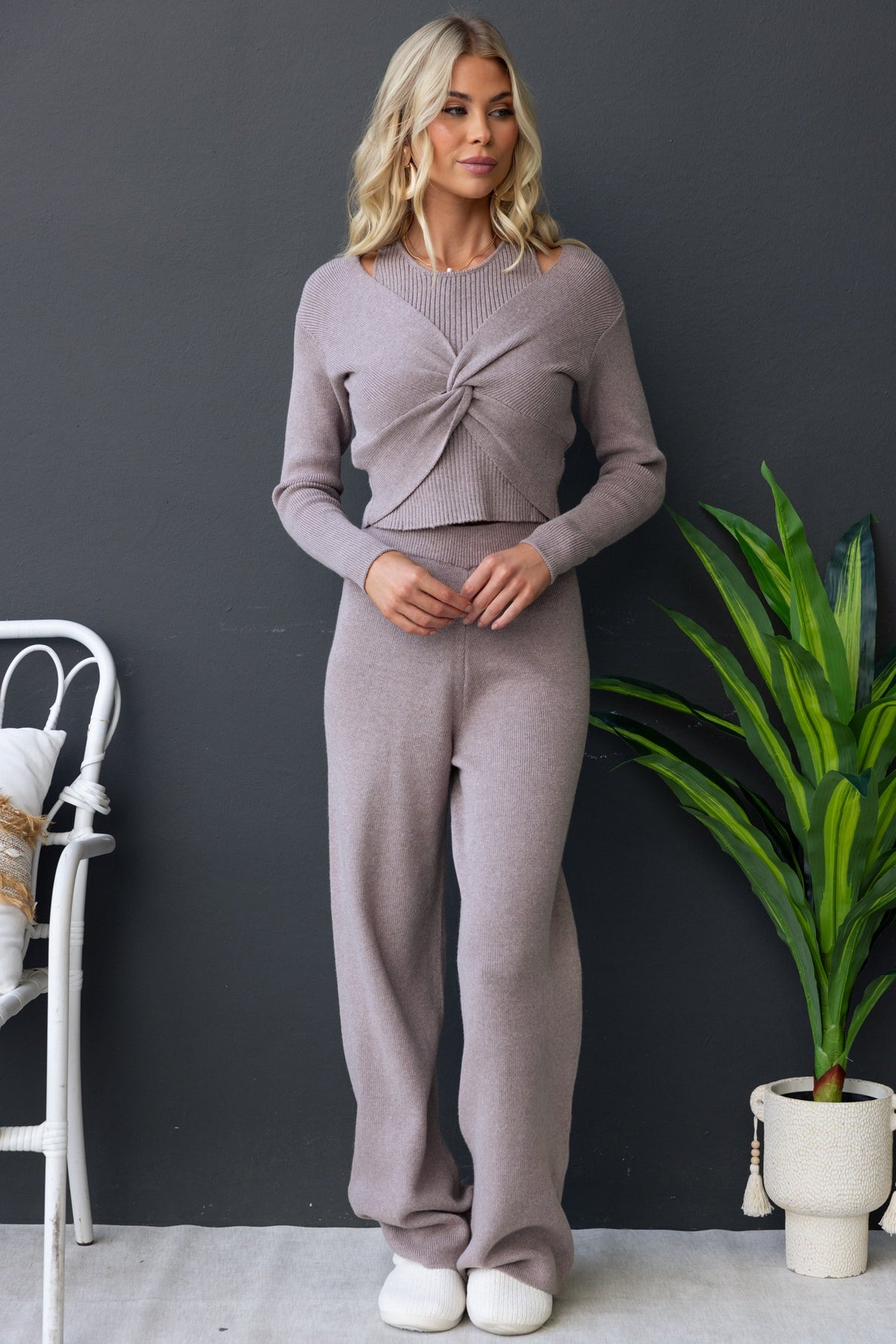 Model wearing the Darana Top in light gray, featuring a twist detail and ribbed knit, styled with matching bottoms.