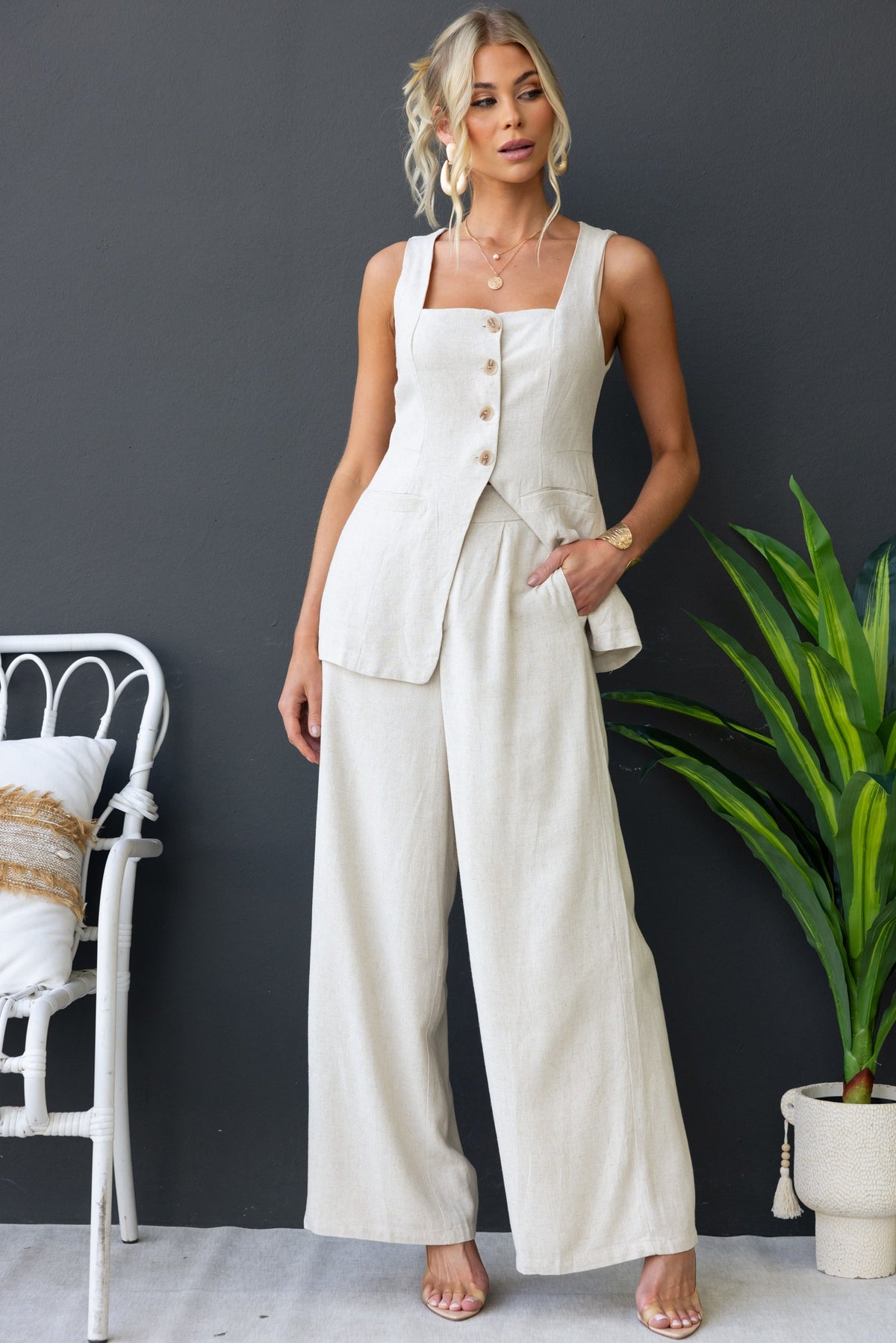 Model wearing Bexley Pants in linen look, featuring mid-high waist, pockets, and a relaxed fit in a stylish setting.