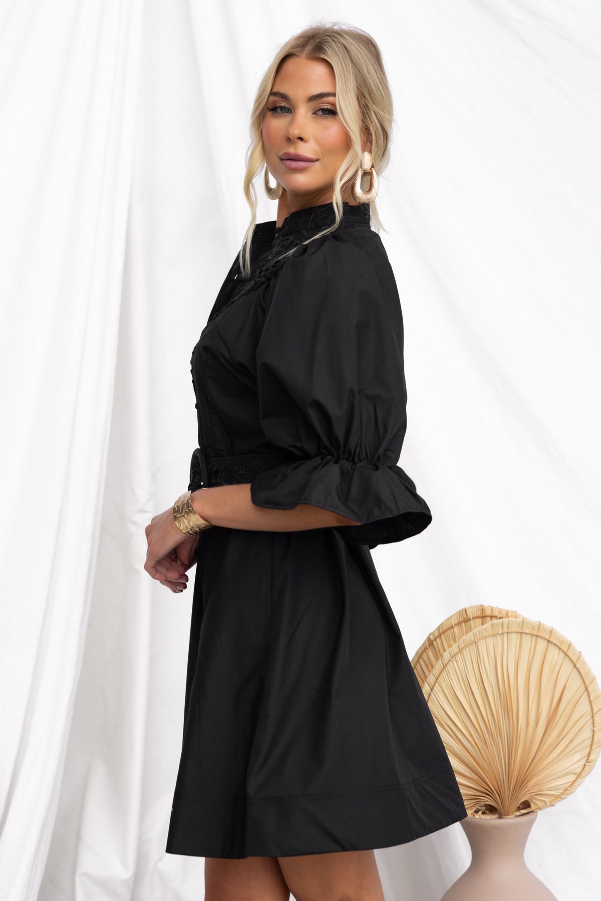 Cortez Dress: stylish black dress with high neckline, button-up front, and lace detailing, featuring a removable belt.