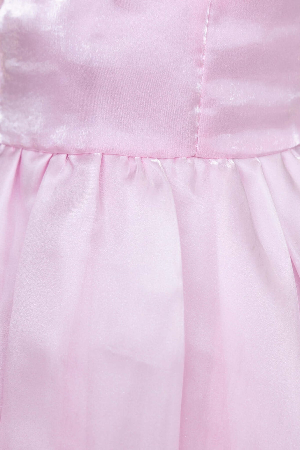 Close-up of pink chiffon dress showing ruffle straps and gathered pleat details in shiny fabric.
