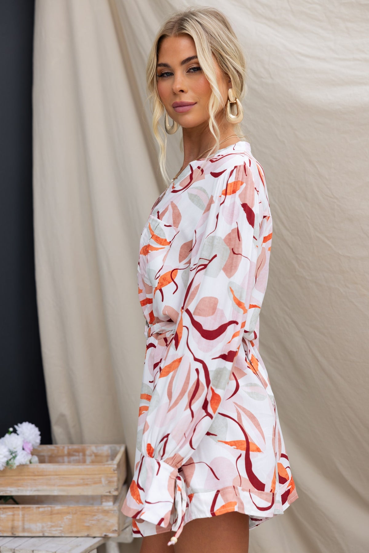 Model wearing Alfred Playsuit with floral design, featuring long sleeves and a relaxed fit.