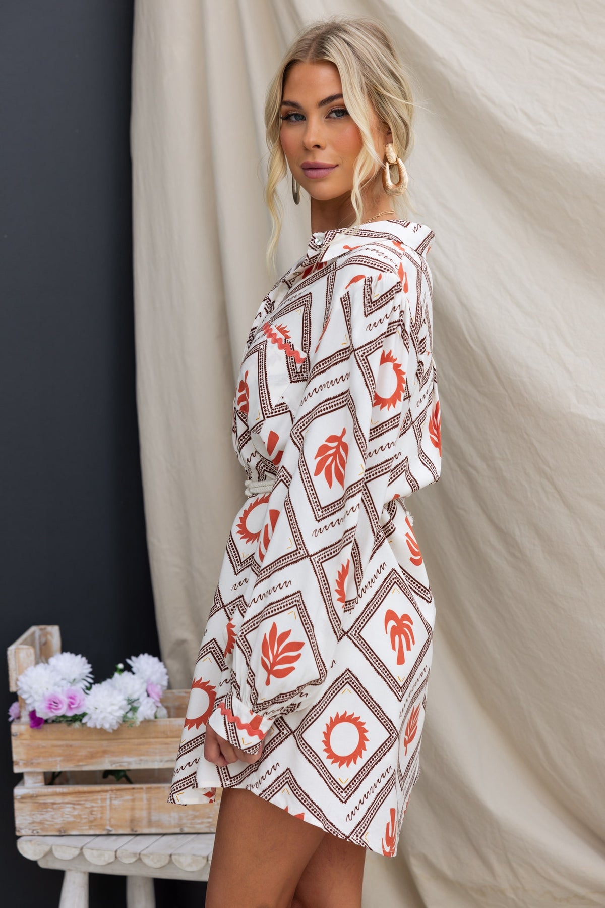 Model wearing the Better Not Dress, featuring a vibrant geometric print and long sleeves for a stylish summer look.