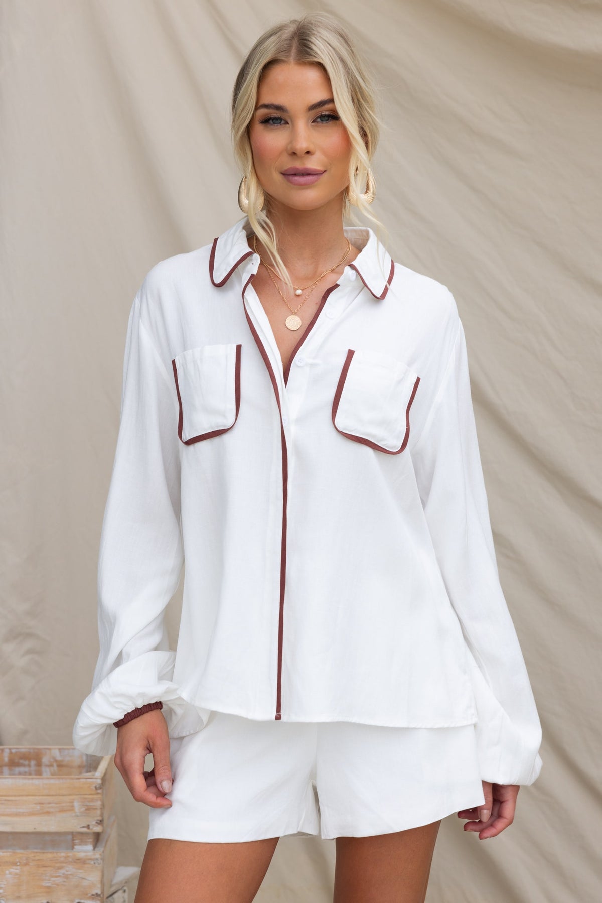 White Ronnie Shirt with button-up front, chest pockets, and relaxed fit, styled with matching shorts.