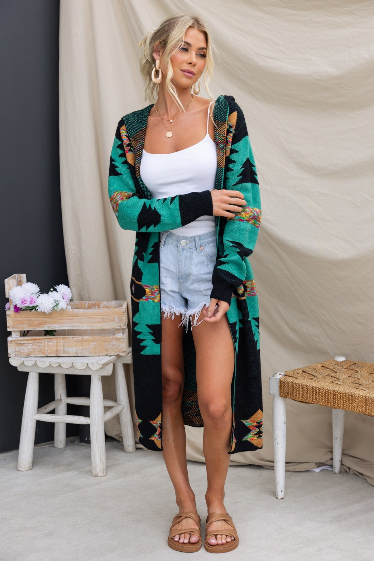 Lazuli Cardigan with black base, longline fit, pockets, and hood. Model wearing size S/M with denim shorts.