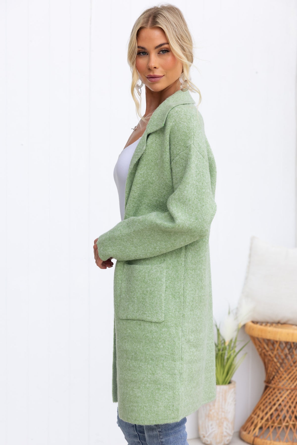 Model wearing a stylish green Sarlia Cardigan with pockets, made from soft knit material, showcasing a relaxed fit.