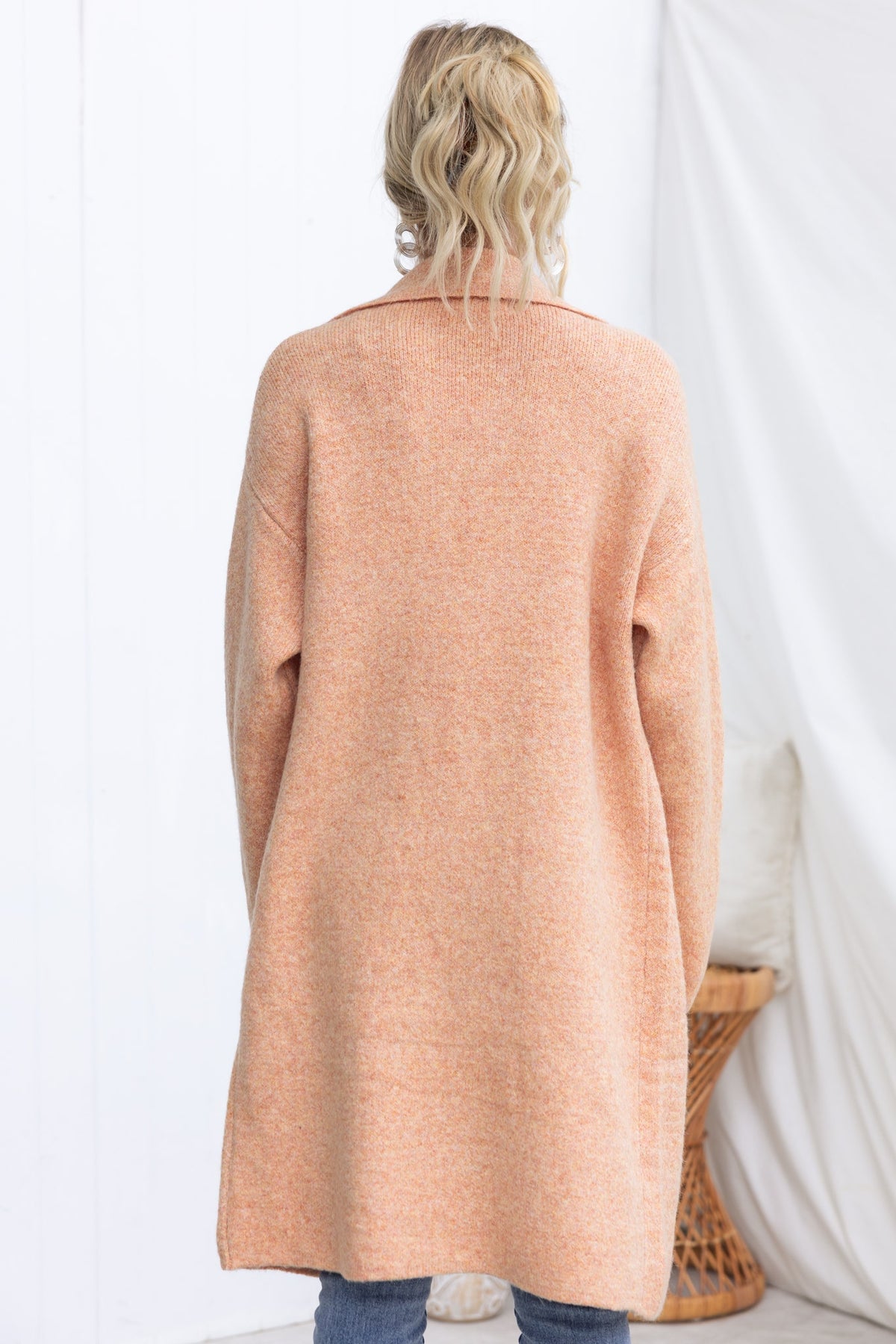Back view of the Sarlia Cardigan in soft orange knit, featuring a relaxed fit and cozy design.